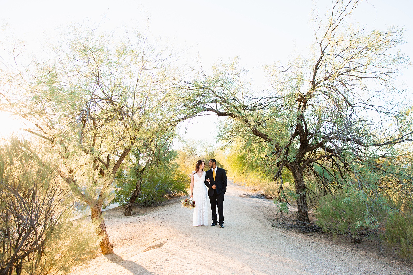 Bride and groom walking together during their Backyard Micro wedding by Scottsdale wedding photographer PMA Photography.