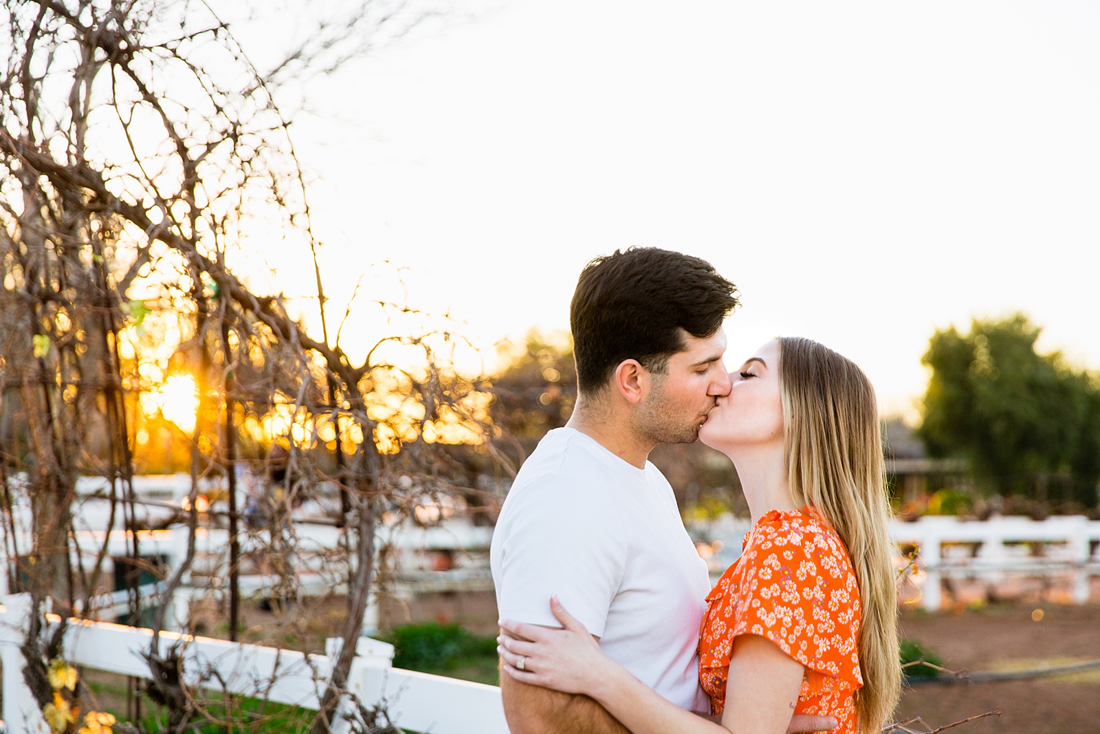 Couple share a kiss during their The Farm at Agritopia engagement session by Gilbert wedding photographer PMA Photography.