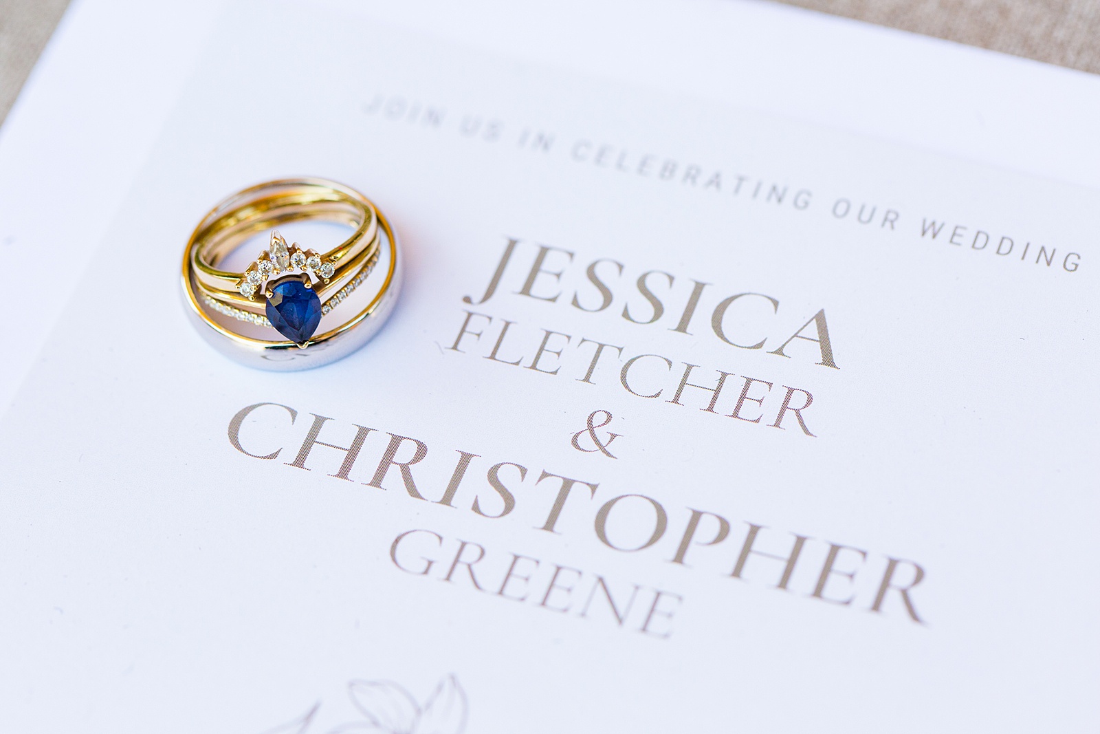 Unique Sapphire wedding ring on top of wedding invitations by Arizona wedding photographer PMA Photography.