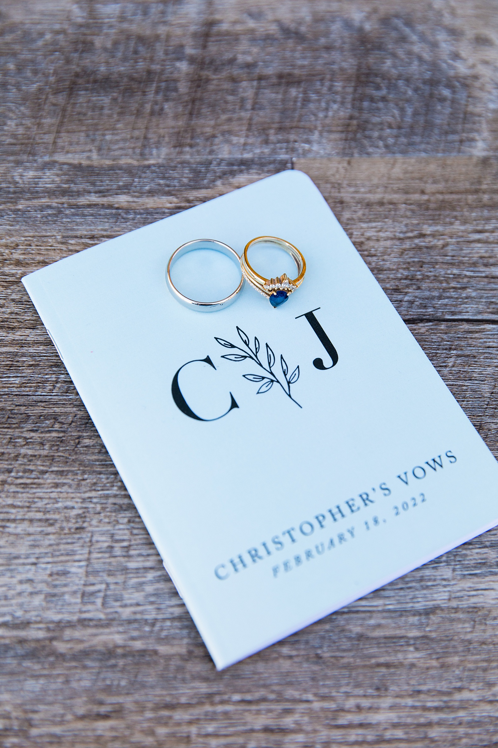 Wedding rings on top of custom vow books by Arizona wedding photographer PMA Photography.