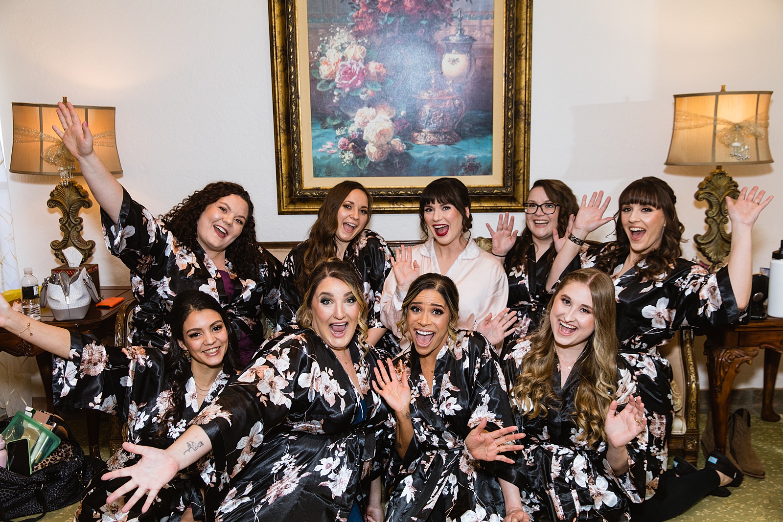 Bride having fun with bridesmaids in their matching satin robes by Chandler wedding photographer PMA Photography.