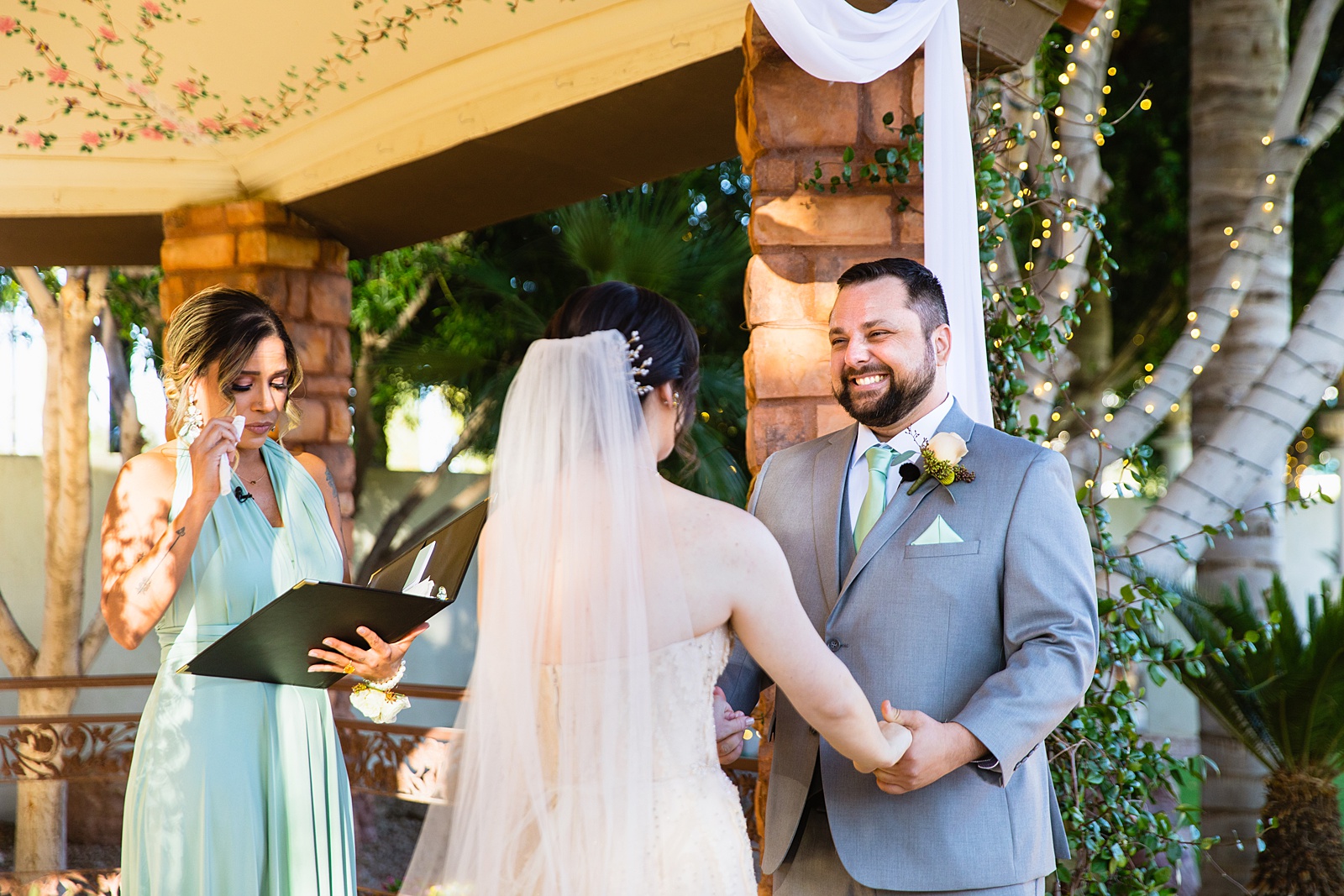 Groom looking at his bride during their wedding ceremony at Bella Rose Estate by Chandler wedding photographer PMA Photography.