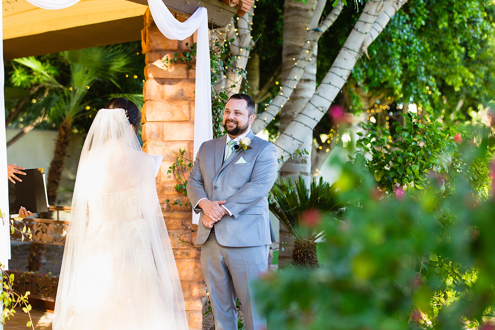 Bride and Groom exchange vows during their Bella Rose Estate wedding ceremony by Chandler wedding photographer PMA Photography.
