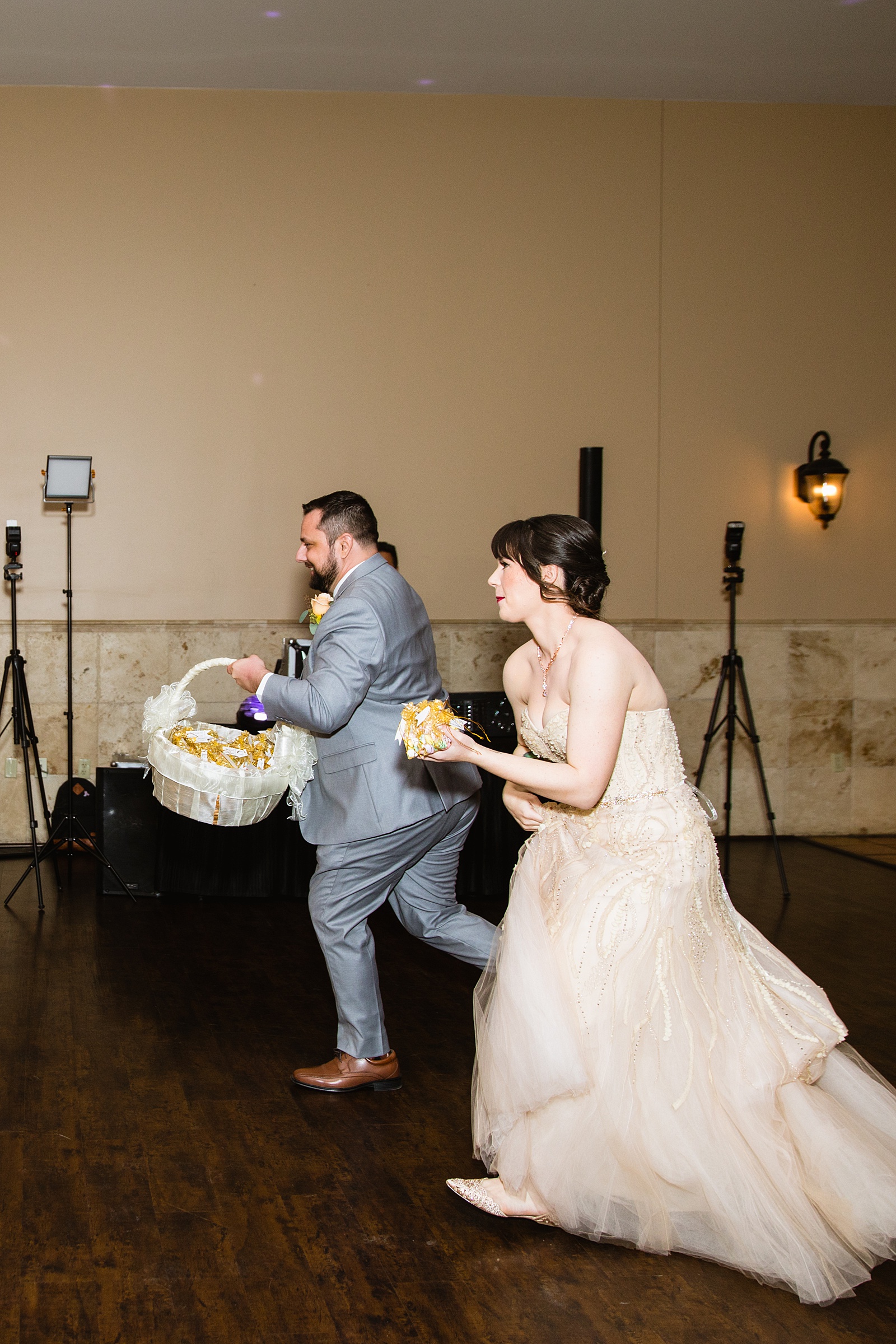 Bride and groom race to guest tables to give out favors and take pictures with each table at a Bella Rose Estate wedding reception by Arizona photographers PMA Photography.