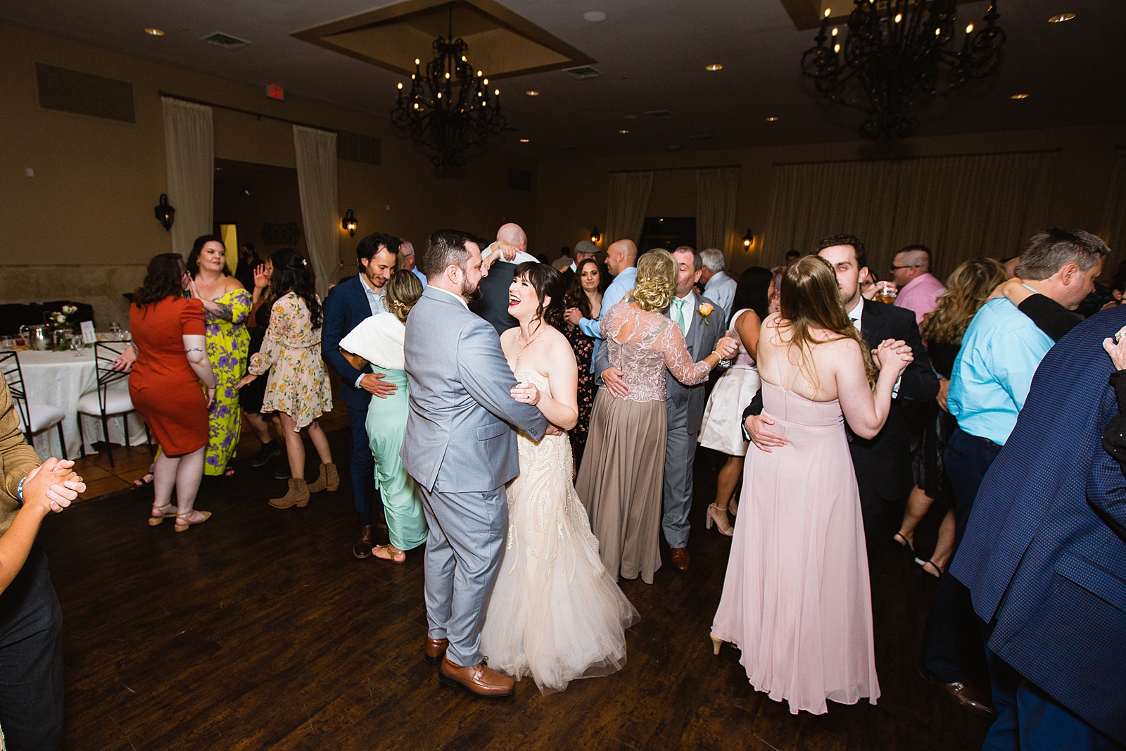 Bride and Groom dancing with guests at their Bella Rose Estate wedding reception by Arizona wedding photographer PMA Photography