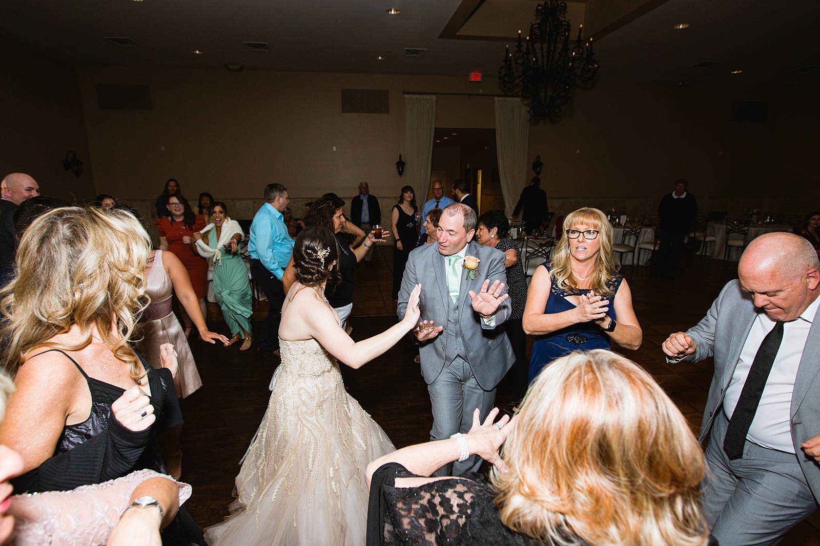 Bride dancing with guests at Bella Rose Estate wedding reception by Chandler wedding photographer PMA Photography