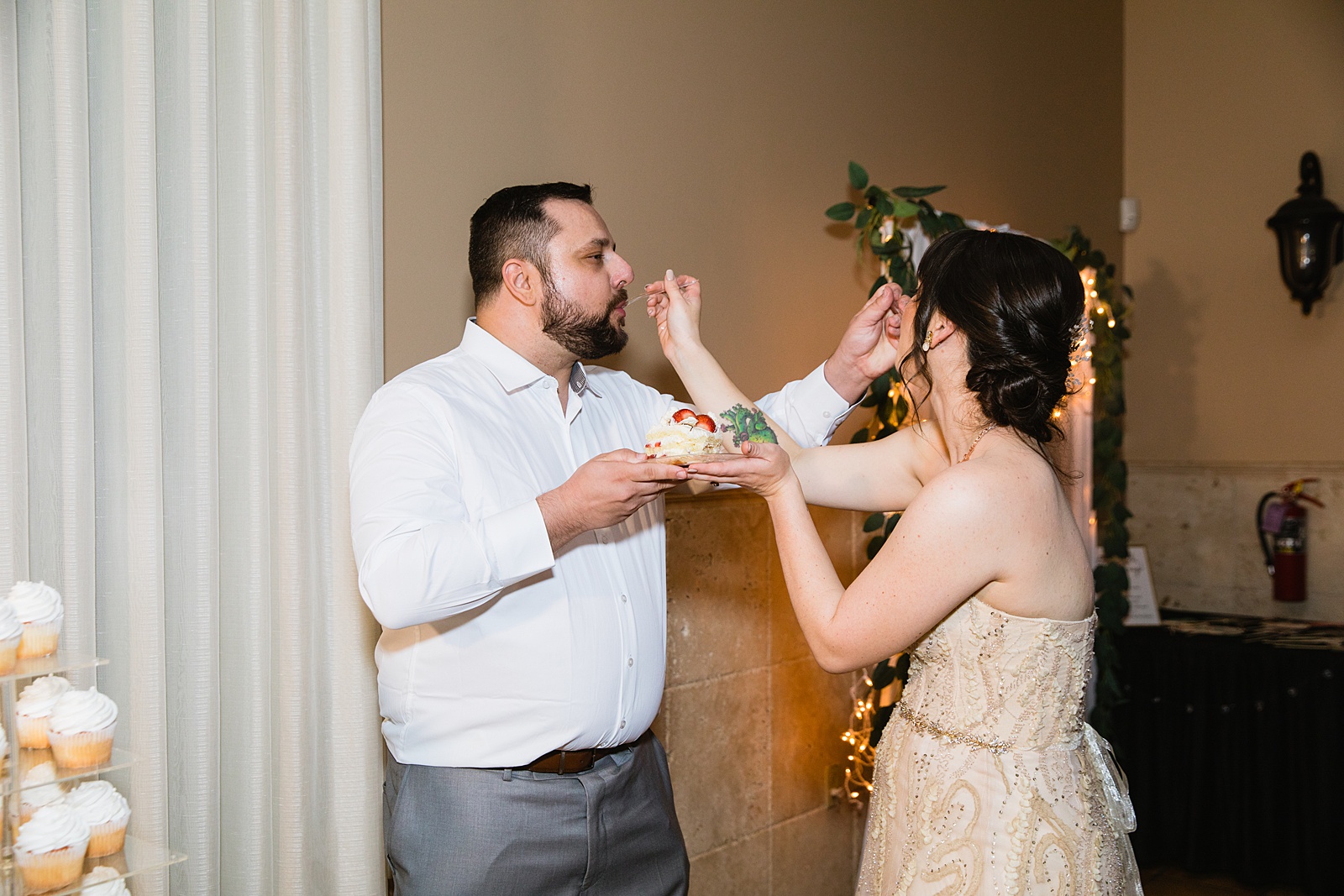 Bride and Groom cutting their wedding cake at their Bella Rose Estate wedding reception by Arizona wedding photographer PMA Photography.