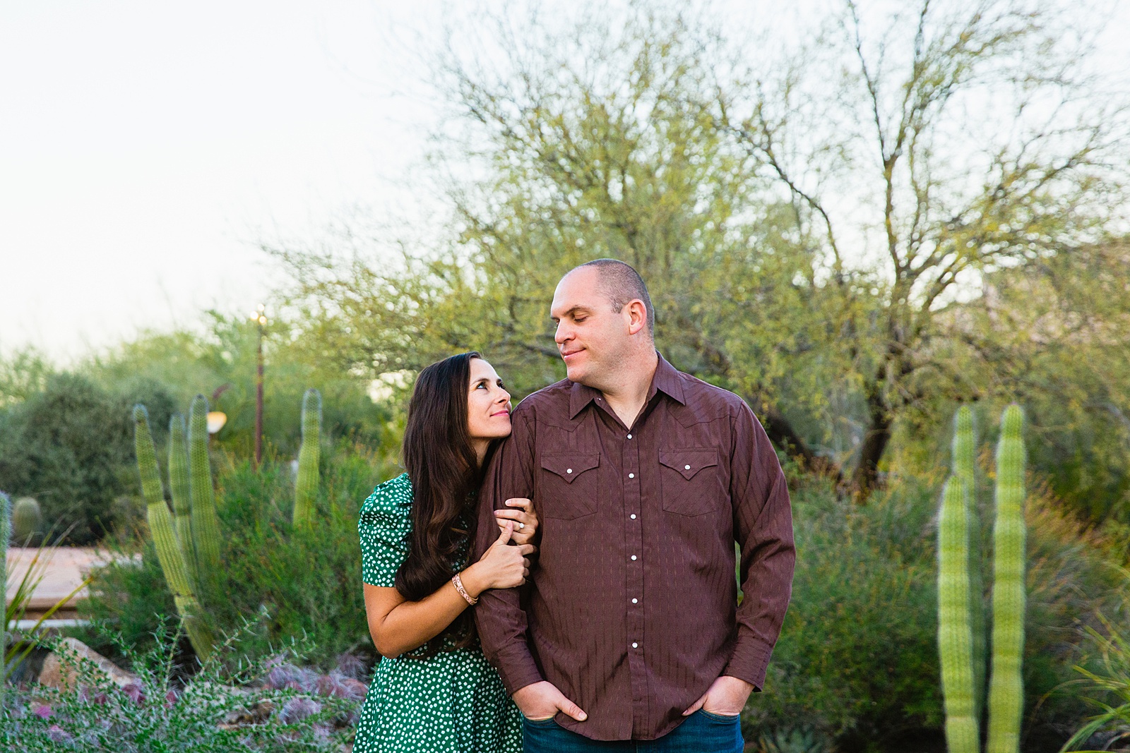 Couple look at each other during their Desert Botanical Garden engagement session by Phoenix wedding photographer PMA Photography.
