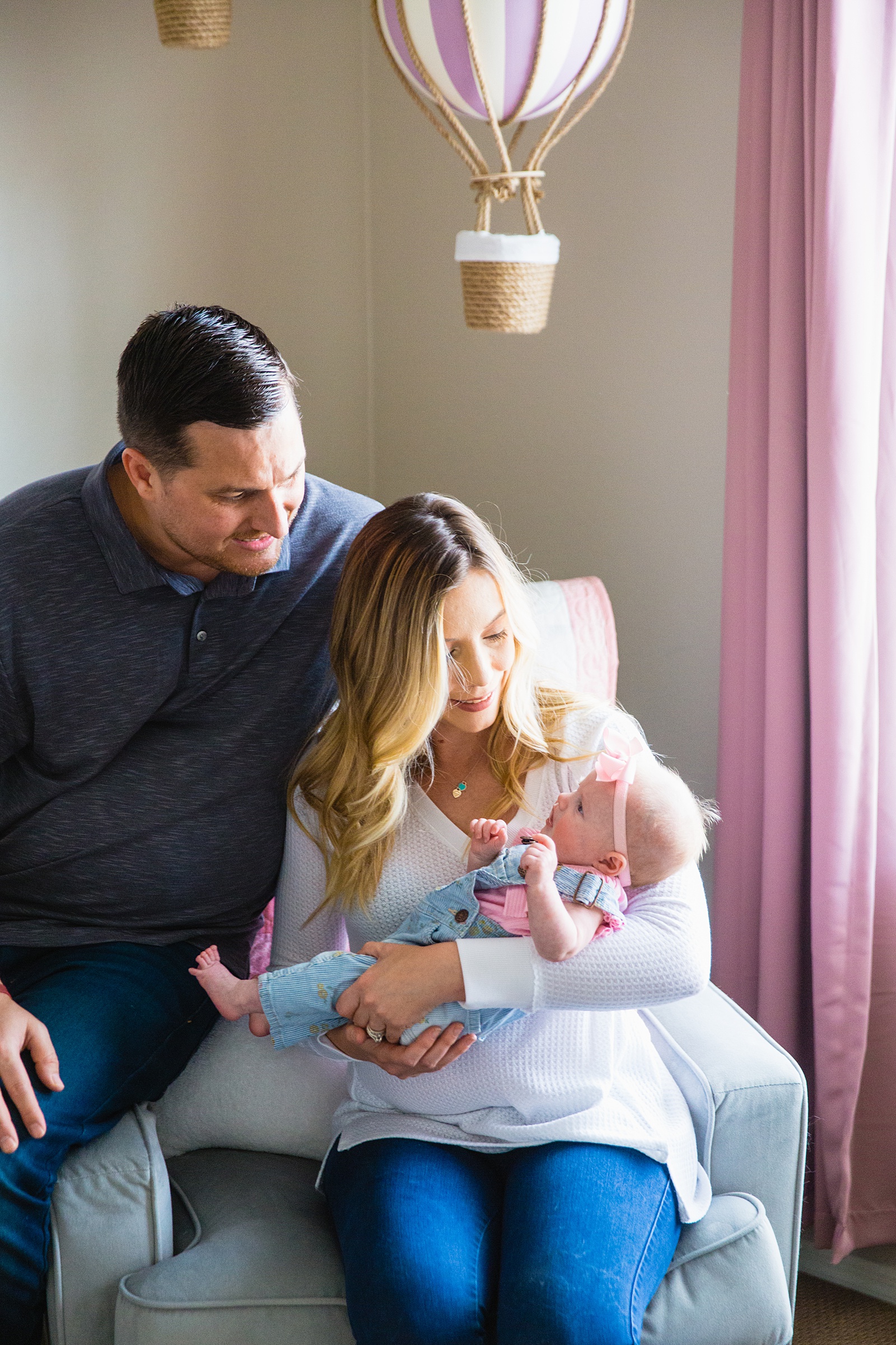 Family look at each other during their at home newborn family session by Phoenix family photographer PMA Photography.