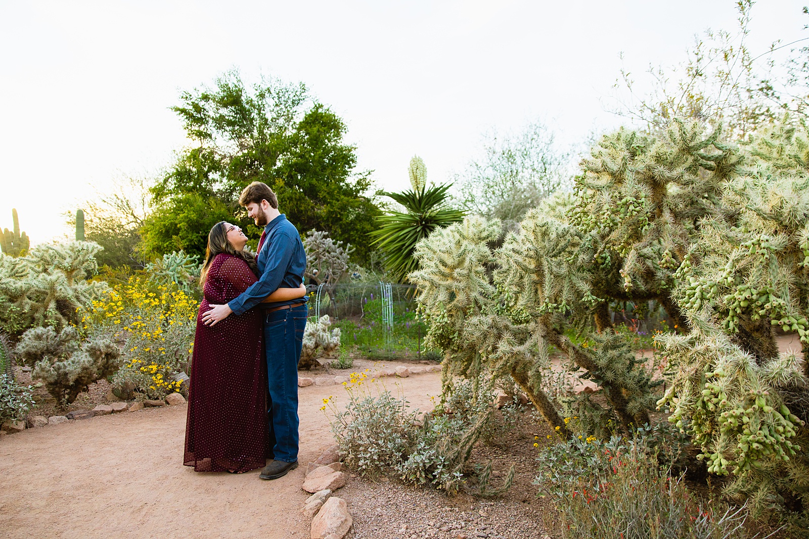 Couple look at each other during their Desert Botanical Gardens engagement session by Phoenix wedding photographer PMA Photography.