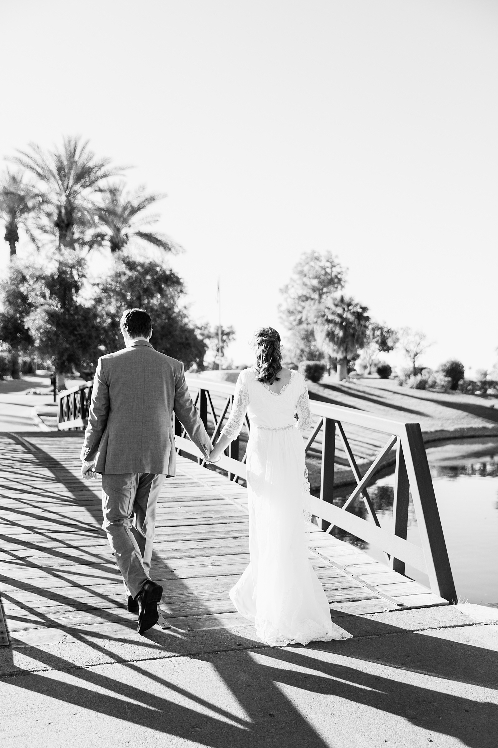Bride and groom walking together during their Ocotillo Oasis wedding by Phoenix wedding photographer PMA Photography.