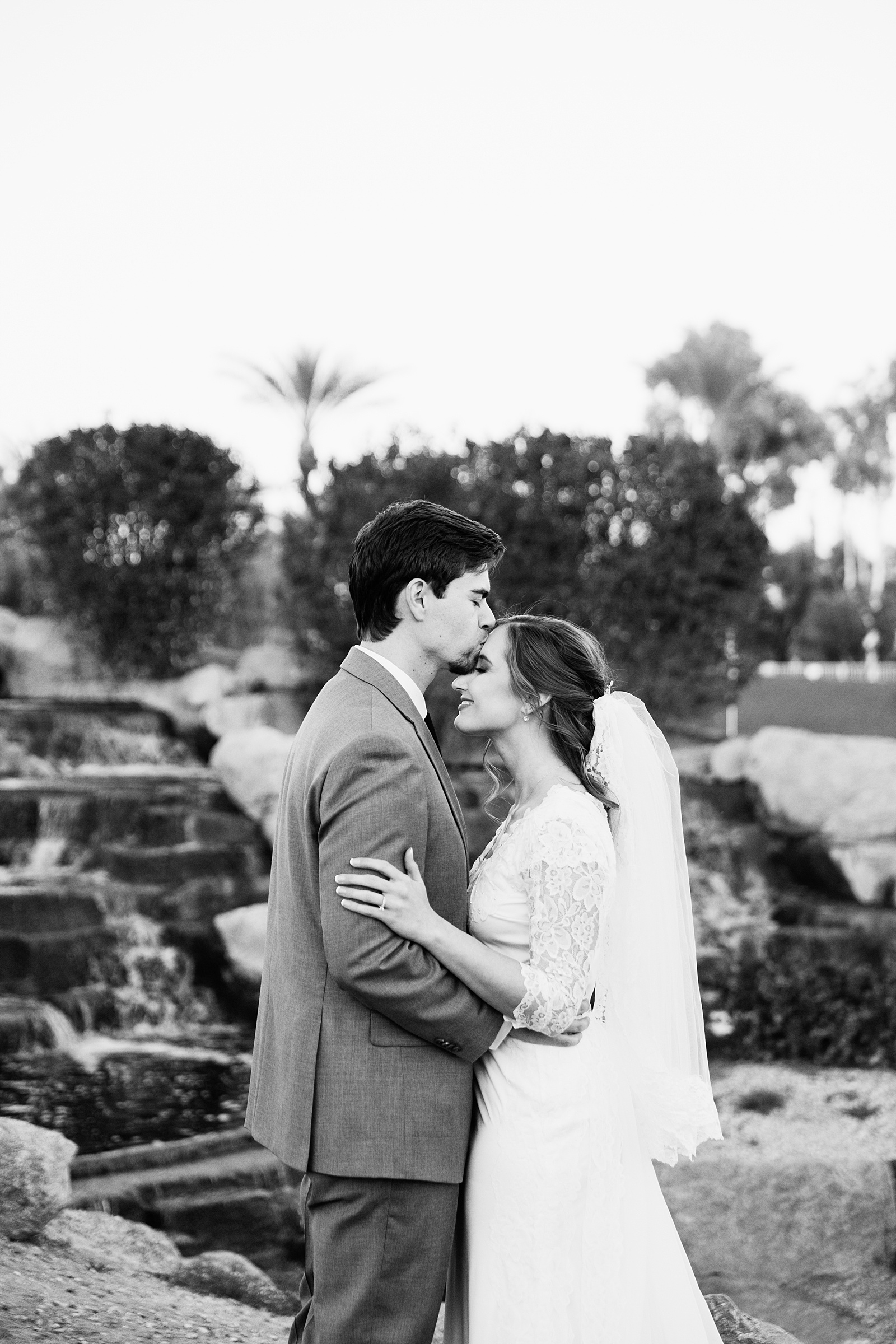 Newlyweds share a kiss during their Ocotillo Oasis wedding by Arizona wedding photographer PMA Photography.