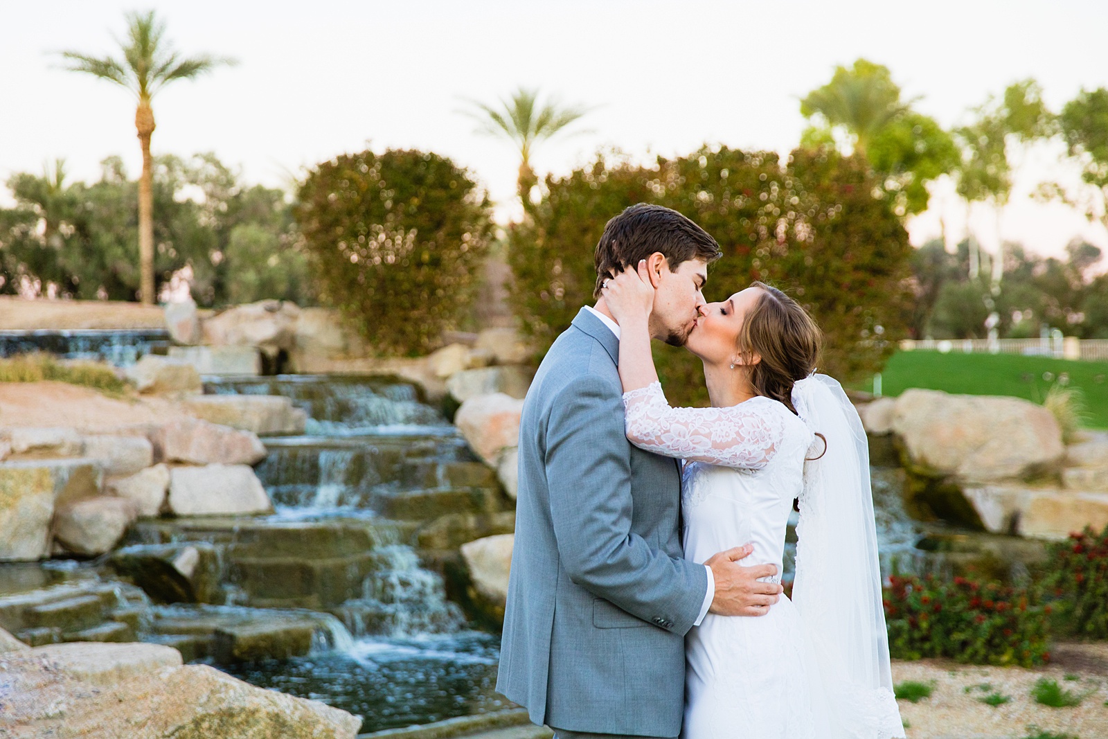 Newlyweds share a kiss during their Ocotillo Oasis wedding by Phoenix wedding photographer PMA Photography.