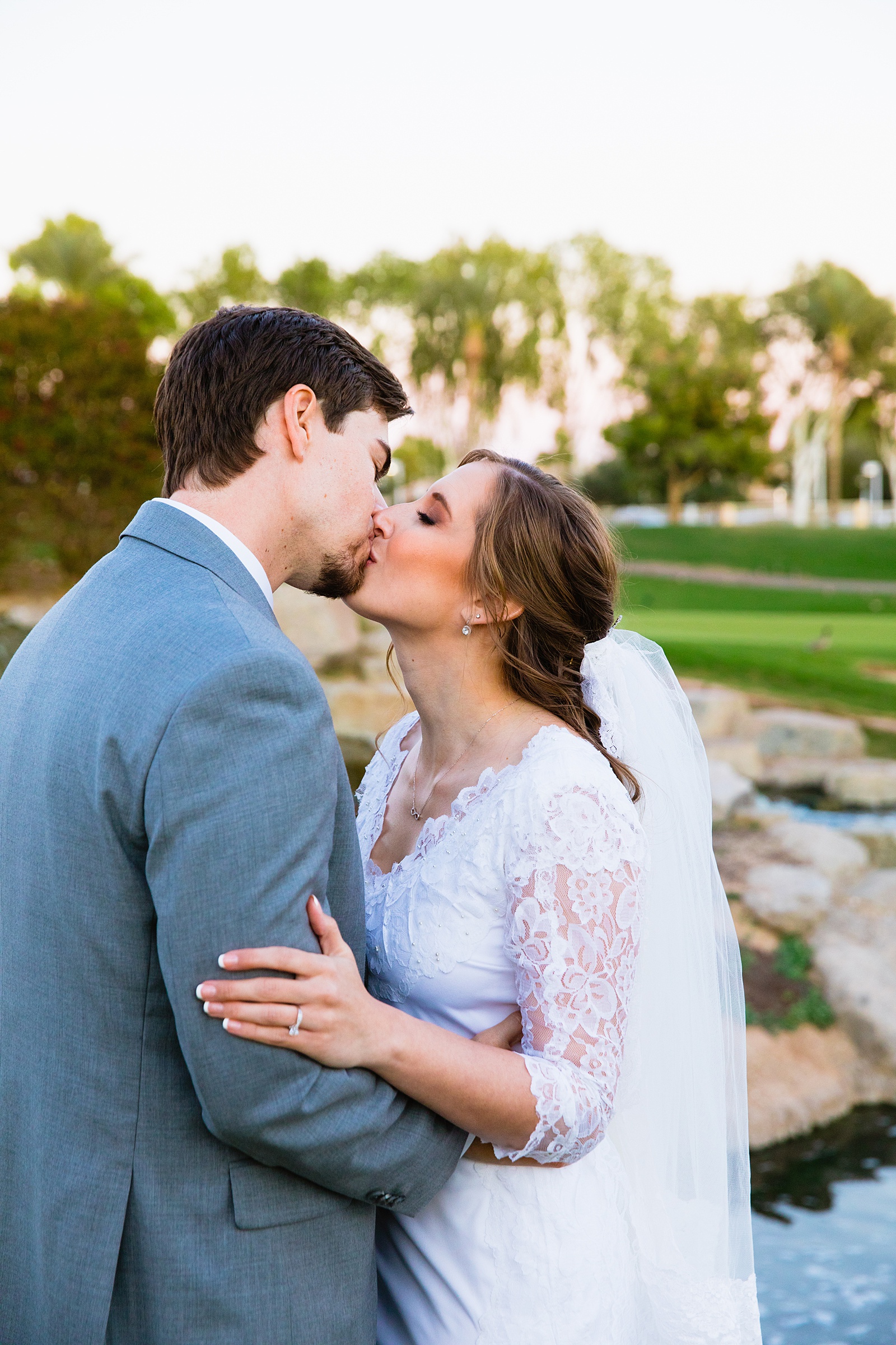 Newlyweds share a kiss during their Ocotillo Oasis wedding by Phoenix wedding photographer PMA Photography.