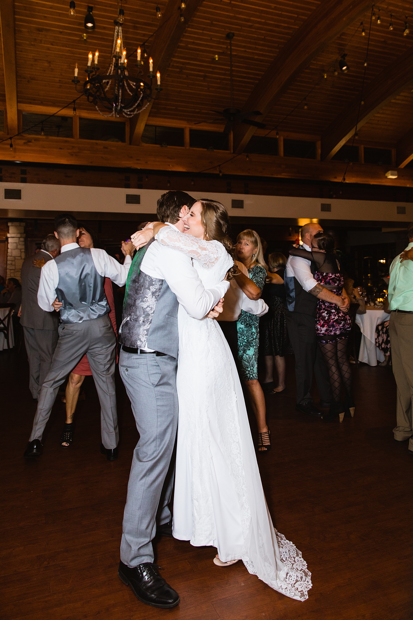 Newlyweds dancing with guests at their Ocotillo Oasis wedding reception by Arizona wedding photographer PMA Photography