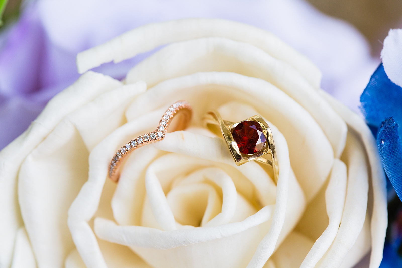Bride's gold and ruby wedding rings in a wedding flower by Arizona wedding photographer PMA Photography.
