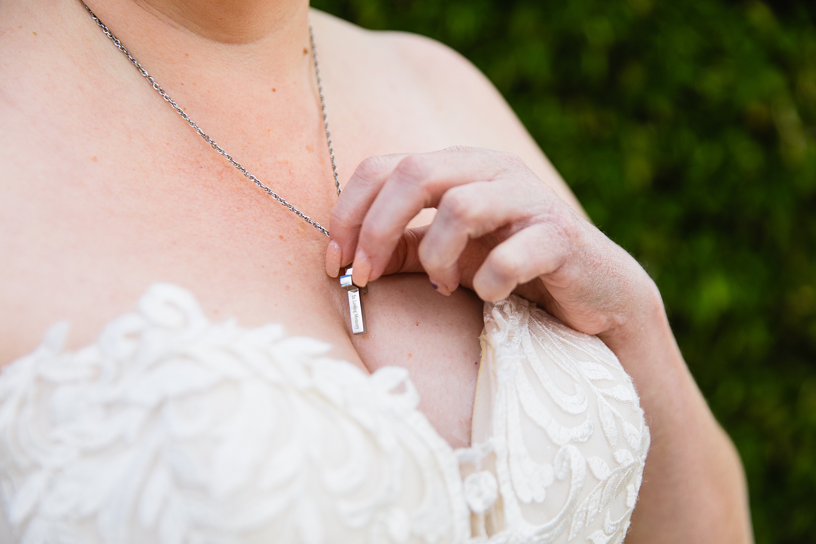 Bride touching her necklace with her mother's ashes at a Sun Valley Church wedding by PMA Photography.