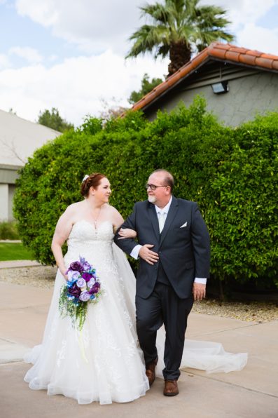 Bride and groom walking together during their Sun Valley Church wedding by Tempe wedding photographer PMA Photography.