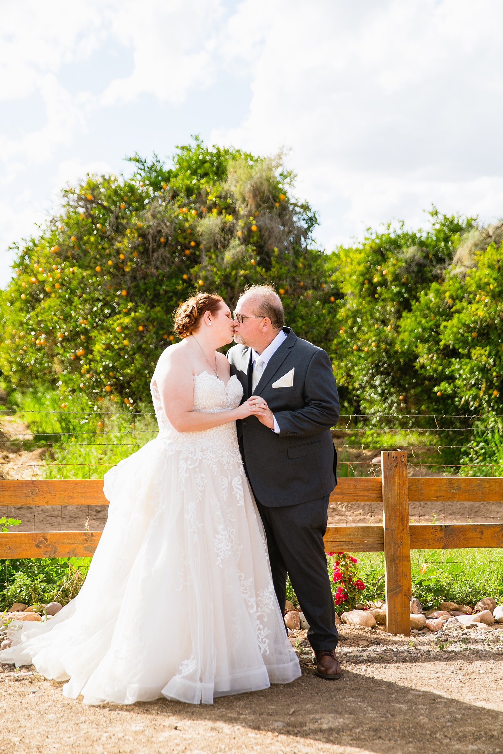 Newlyweds share a kiss during their 101 Polo Club wedding by Arizona wedding photographer PMA Photography.