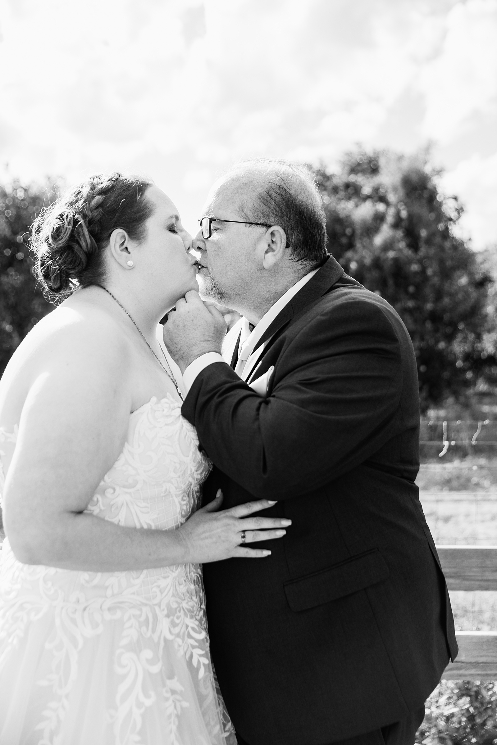 Newlyweds share a kiss during their 101 Polo Club wedding by Tempe wedding photographer PMA Photography.