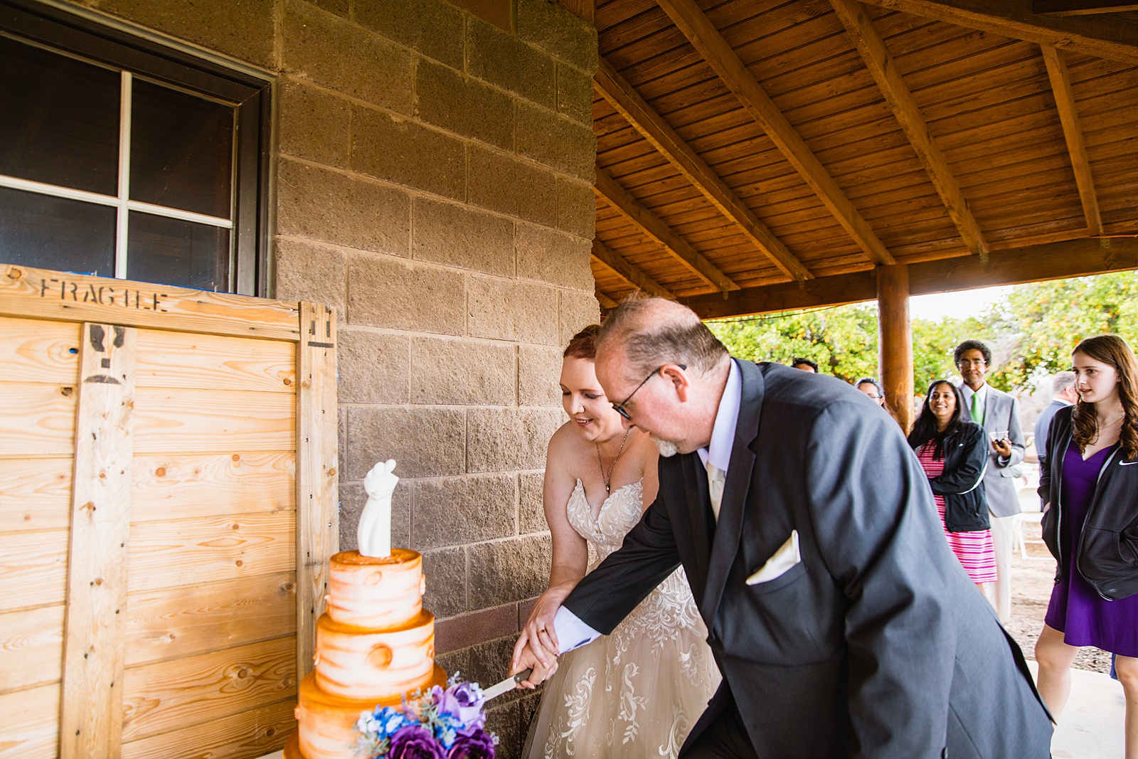Newlyweds cutting their wedding cake at their 101 Polo Club wedding reception by Arizona wedding photographer PMA Photography.