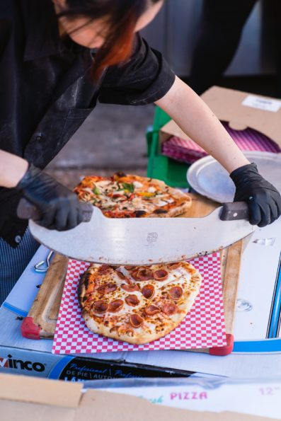 Woodfire pizza being cut for dinner at a 101 Polo club wedding reception by Tempe wedding photographer PMA Photography.