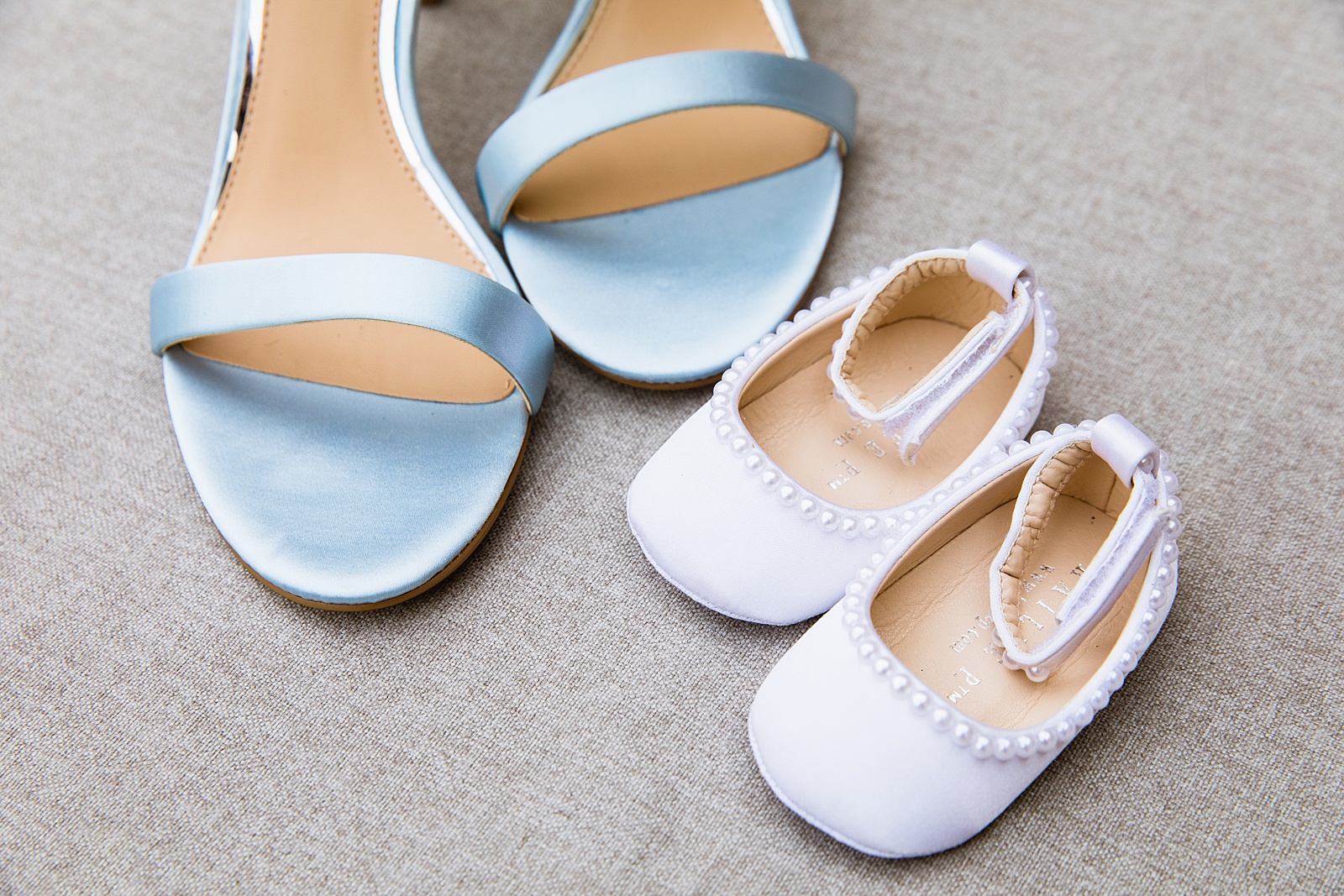 Bride's shoes with her daughter's flower girl shoes by PMA Photography.