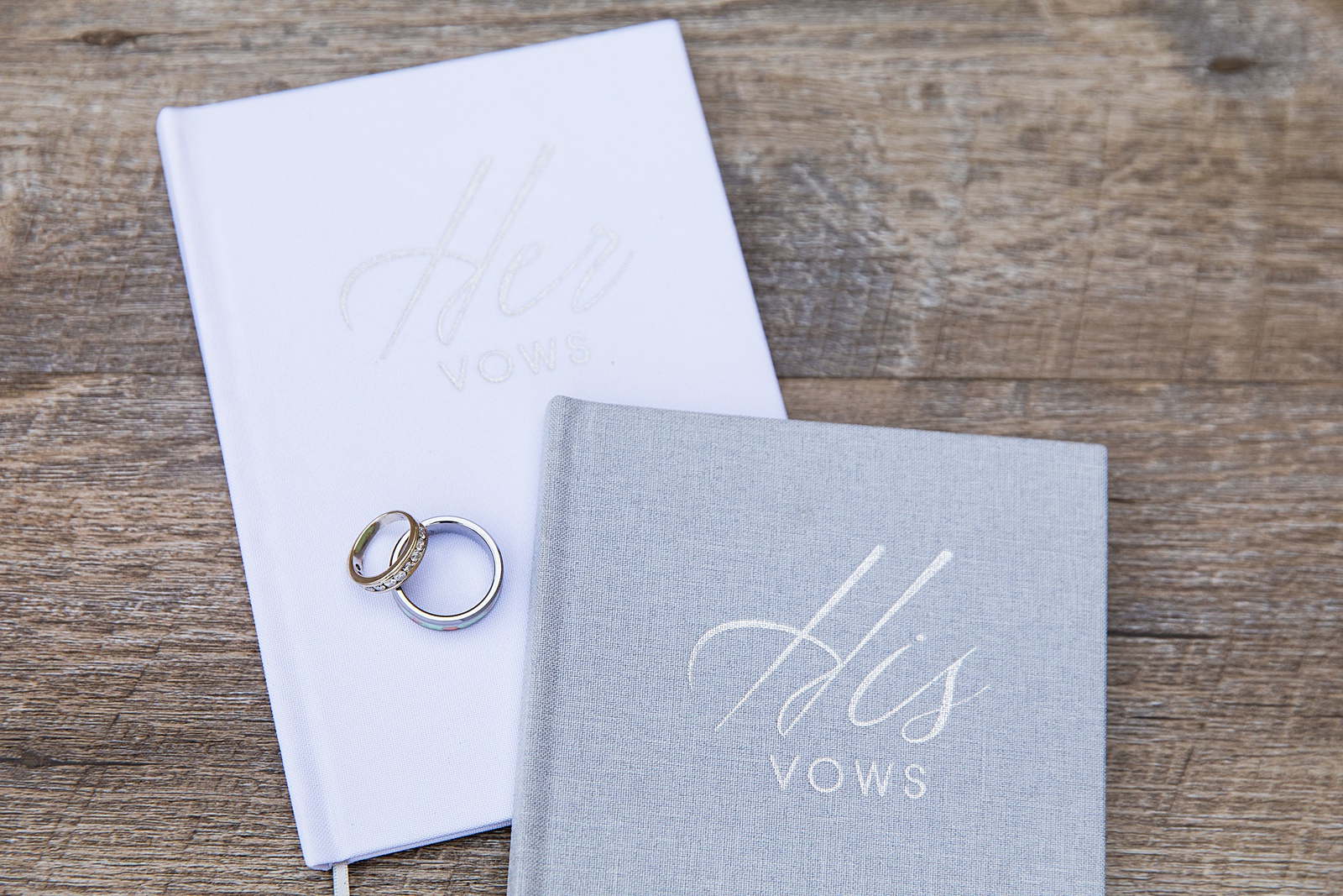 Bride and groom's wedding rings on their vow books by Arizona wedding photographer PMA Photography.
