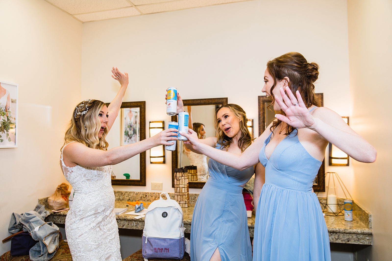 Bride toasting with bridesmaids while getting ready at a Brides romantic, lace wedding dress at her desert wedding at Troon North by Scottsdale wedding photographer PMA Photography.