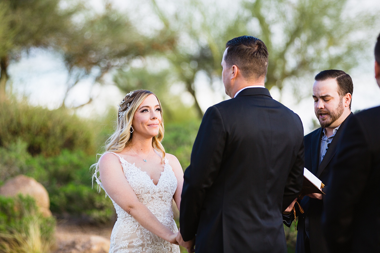 Bride looking at her groom during their wedding ceremony at Troon North by Scottsdale wedding photographer PMA Photography.