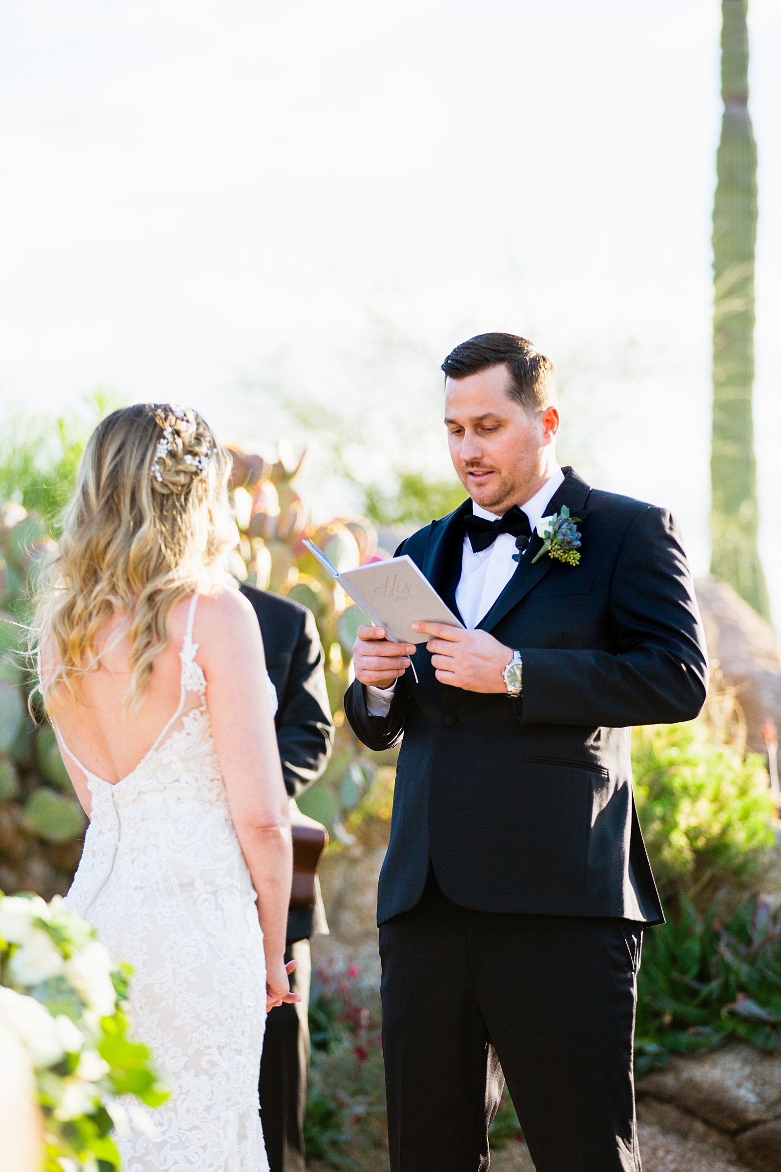 Bride and groom exchange vows during their Troon North wedding ceremony by Scottsdale wedding photographer PMA Photography.
