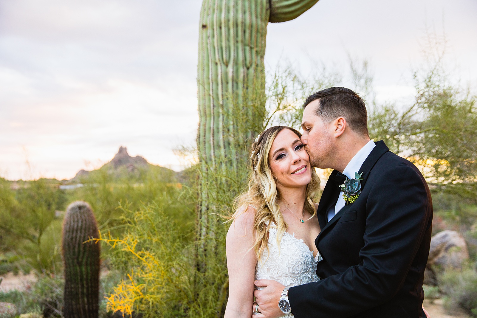 Newlyweds share a kiss during their Troon North wedding by Arizona wedding photographer PMA Photography.