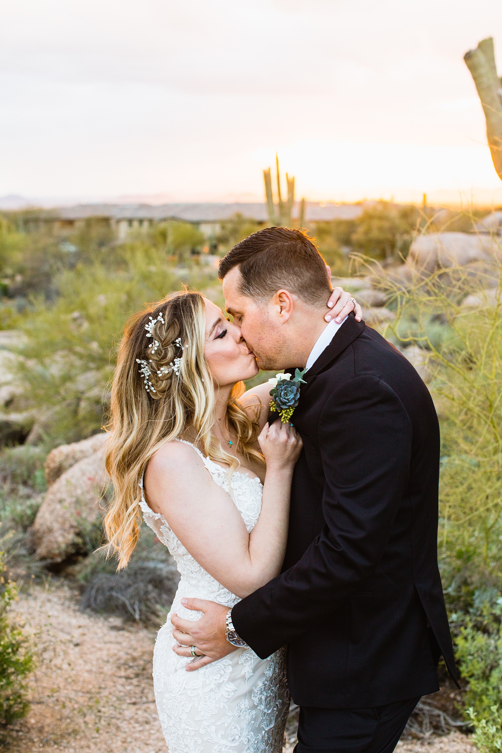 Newlyweds share a kiss during their Troon North wedding by Scottsdale wedding photographer PMA Photography.
