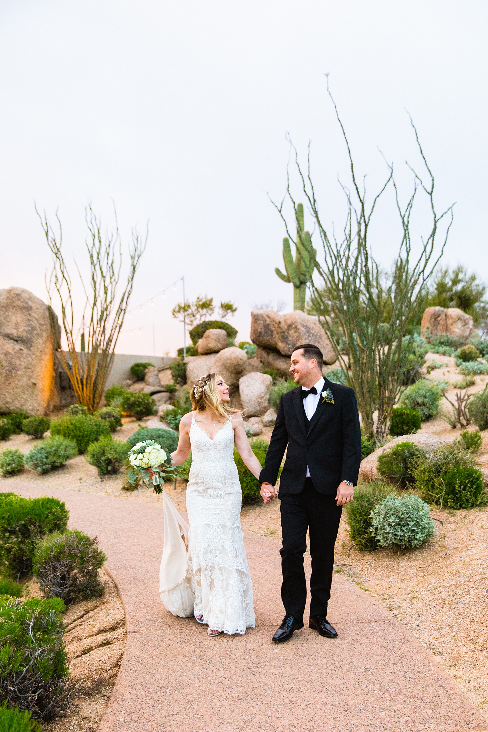 Newlyweds walking together during their Troon North wedding by Scottsdale wedding photographer PMA Photography.
