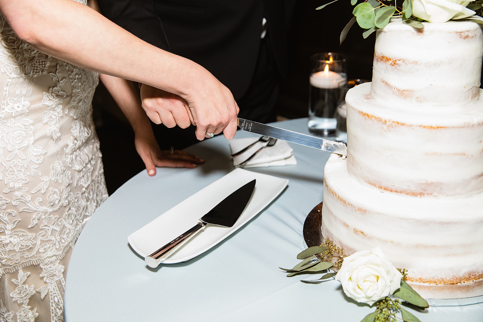 Newlyweds cutting their wedding cake at their Troon North wedding reception by Arizona wedding photographer PMA Photography.
