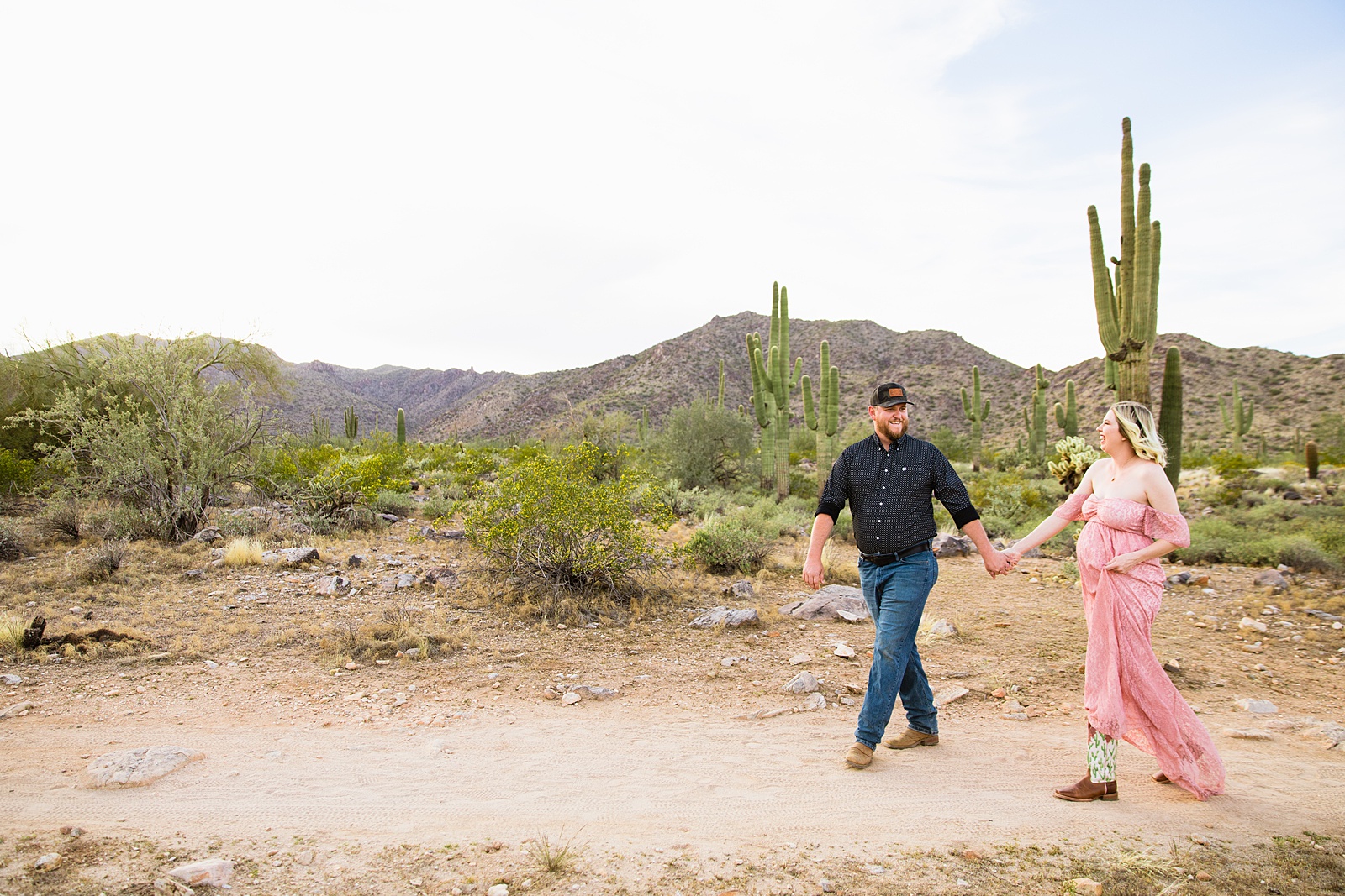 Couple walking together during their Phoenix maternity session by Arizona maternity photographer PMA Photography.