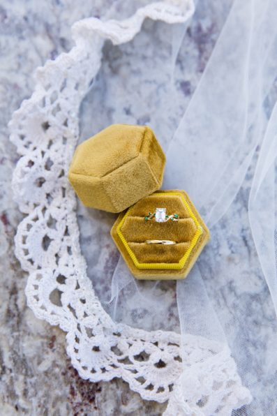 Bride's wedding day details of her yellow hexagon ring box and wedding bands and veil by PMA Photography.