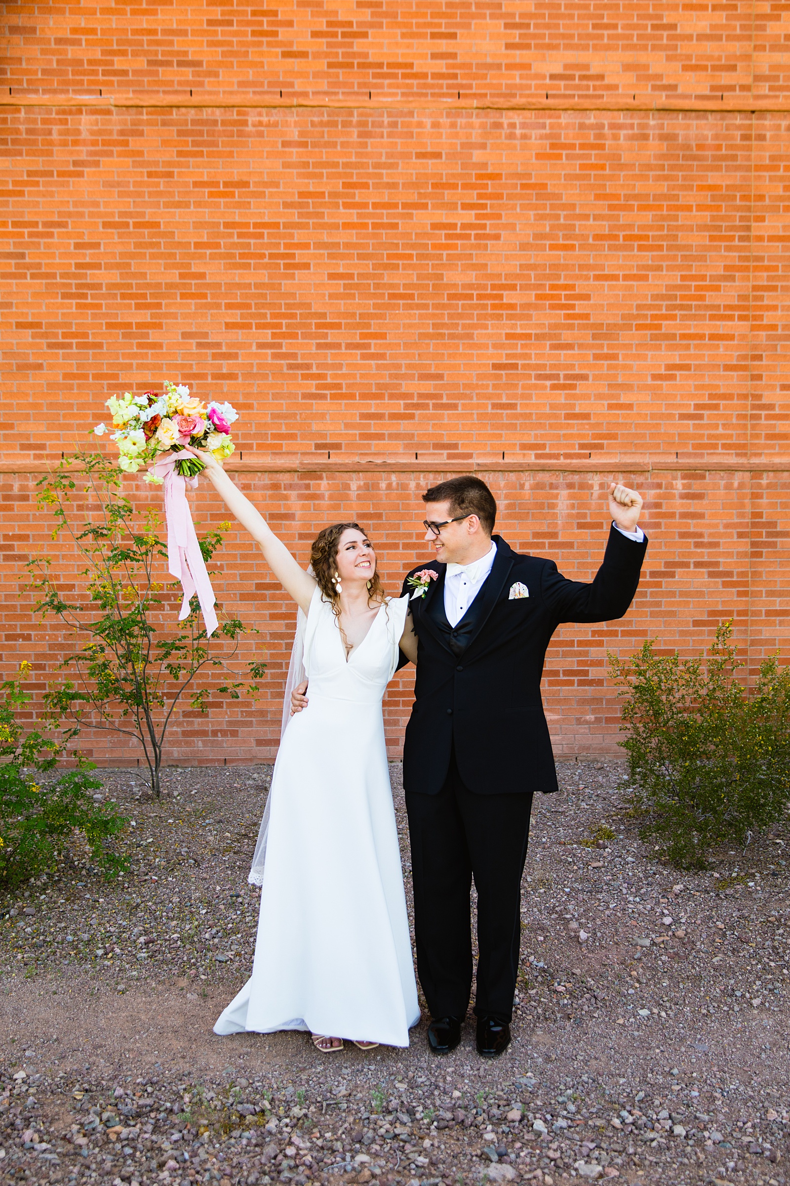 Bride and groom having fun together during their Arizona Historical Society wedding by Tempe wedding photographer PMA Photography.