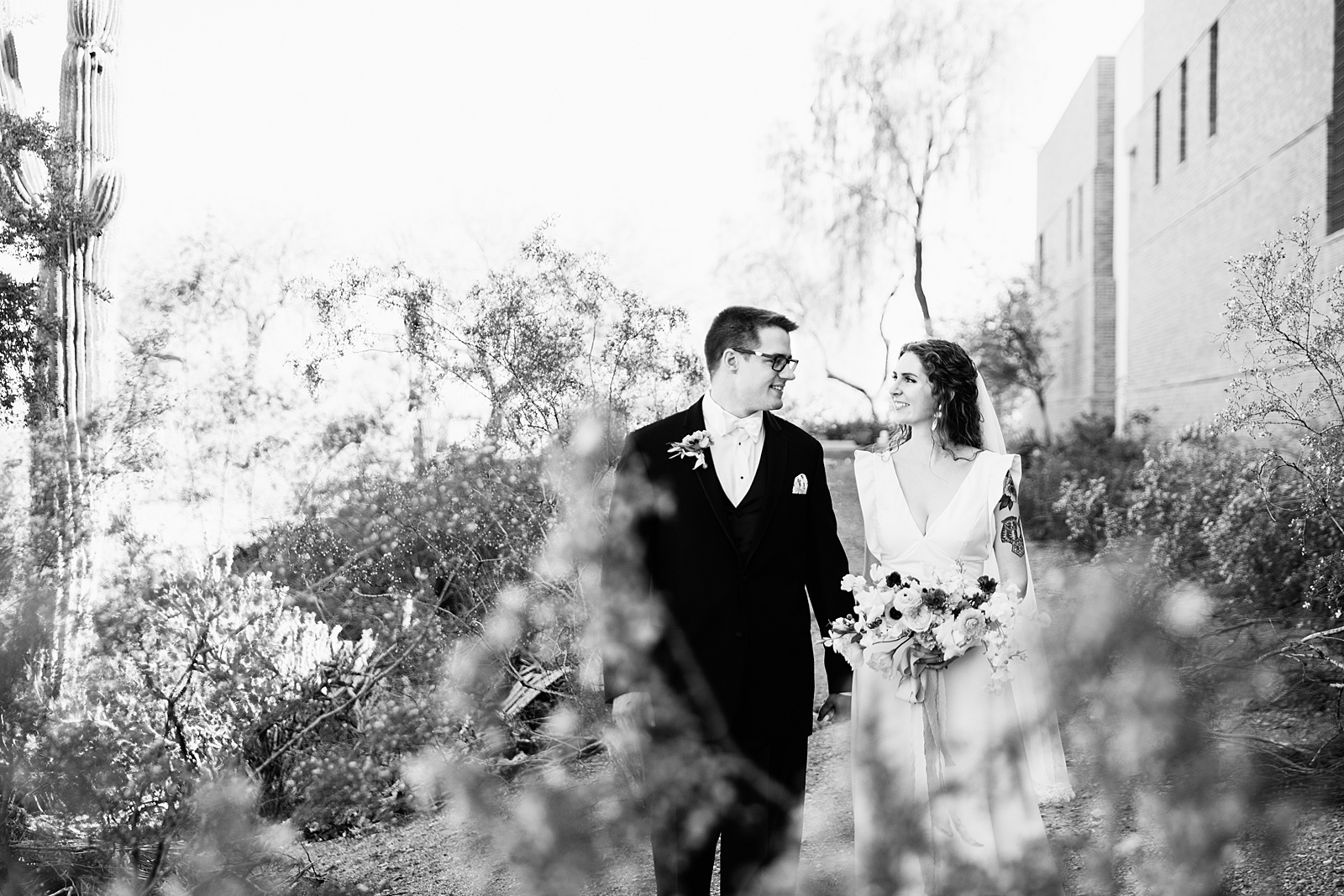 Bride and groom walking together during their Arizona Historical Society wedding by Tempe wedding photographer PMA Photography.