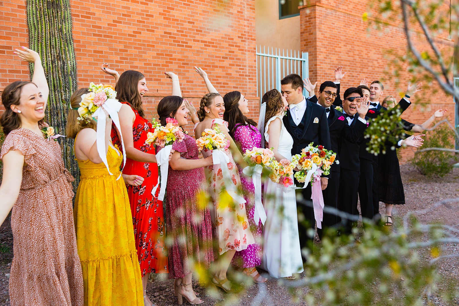 Mixed gender bridal party laughing together at Arizona Historical Society wedding by Tempe wedding photographer PMA Photography.