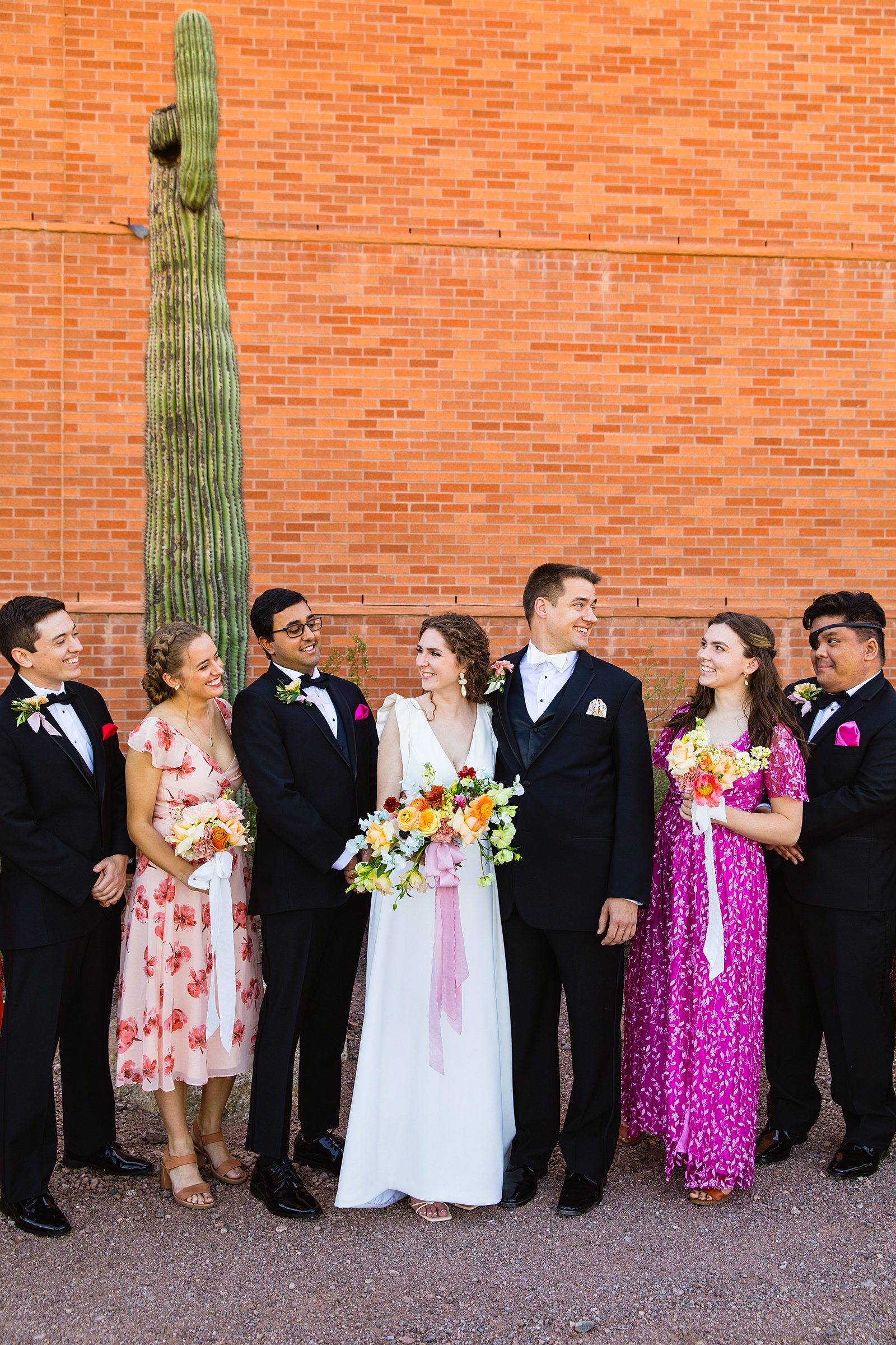 Mixed gender bridal party laughing together at Arizona Historical Society wedding by Tempe wedding photographer PMA Photography.