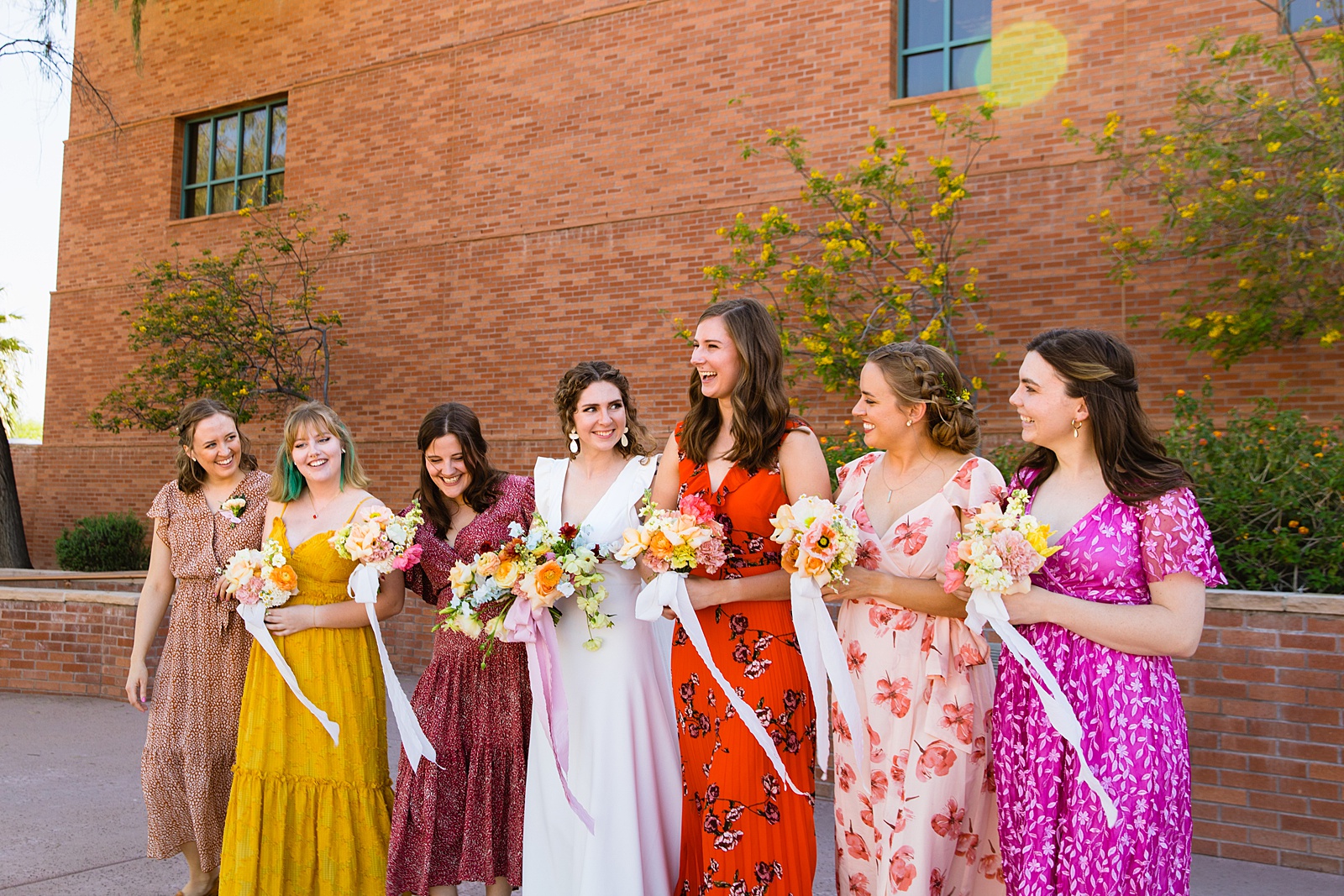 Bride and bridesmaids laughing together at Arizona Historical Society wedding by Tempe wedding photographer PMA Photography.