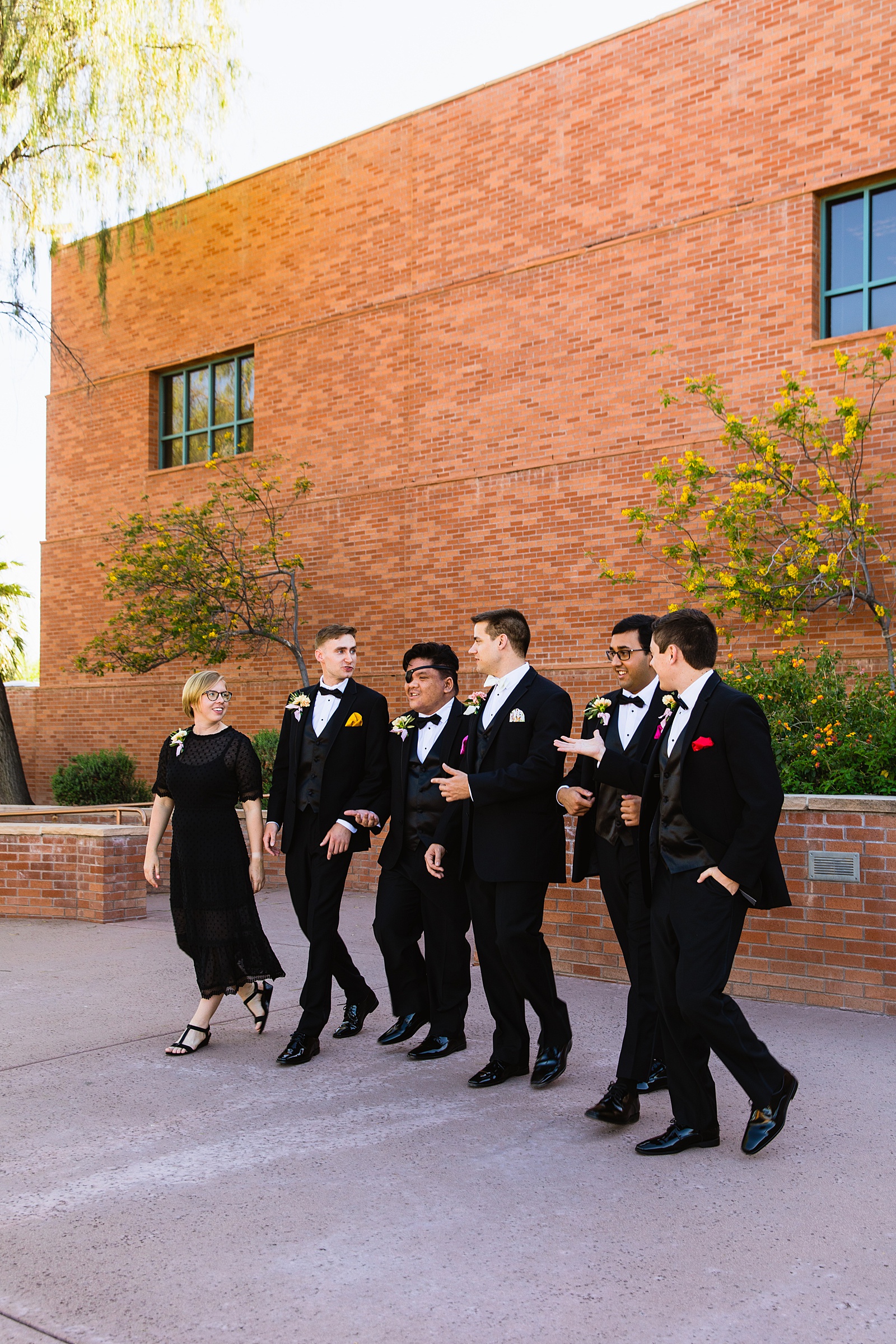 Groom and mixed gender bridal party laughing together at Arizona Historical Society wedding by Tempe wedding photographer PMA Photography.