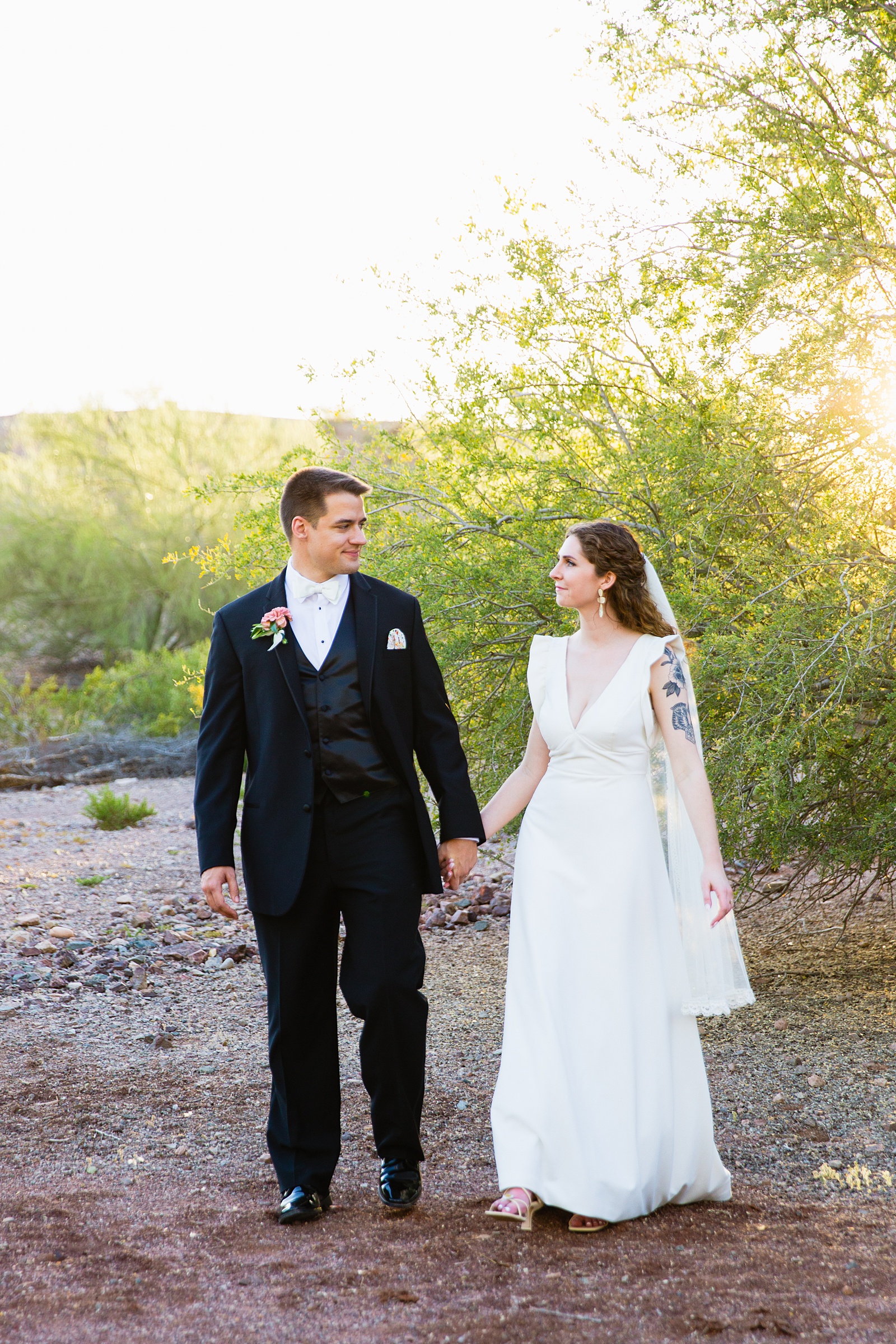 Bride and groom walking together during their Arizona Historical Society wedding by Arizona wedding photographer PMA Photography.