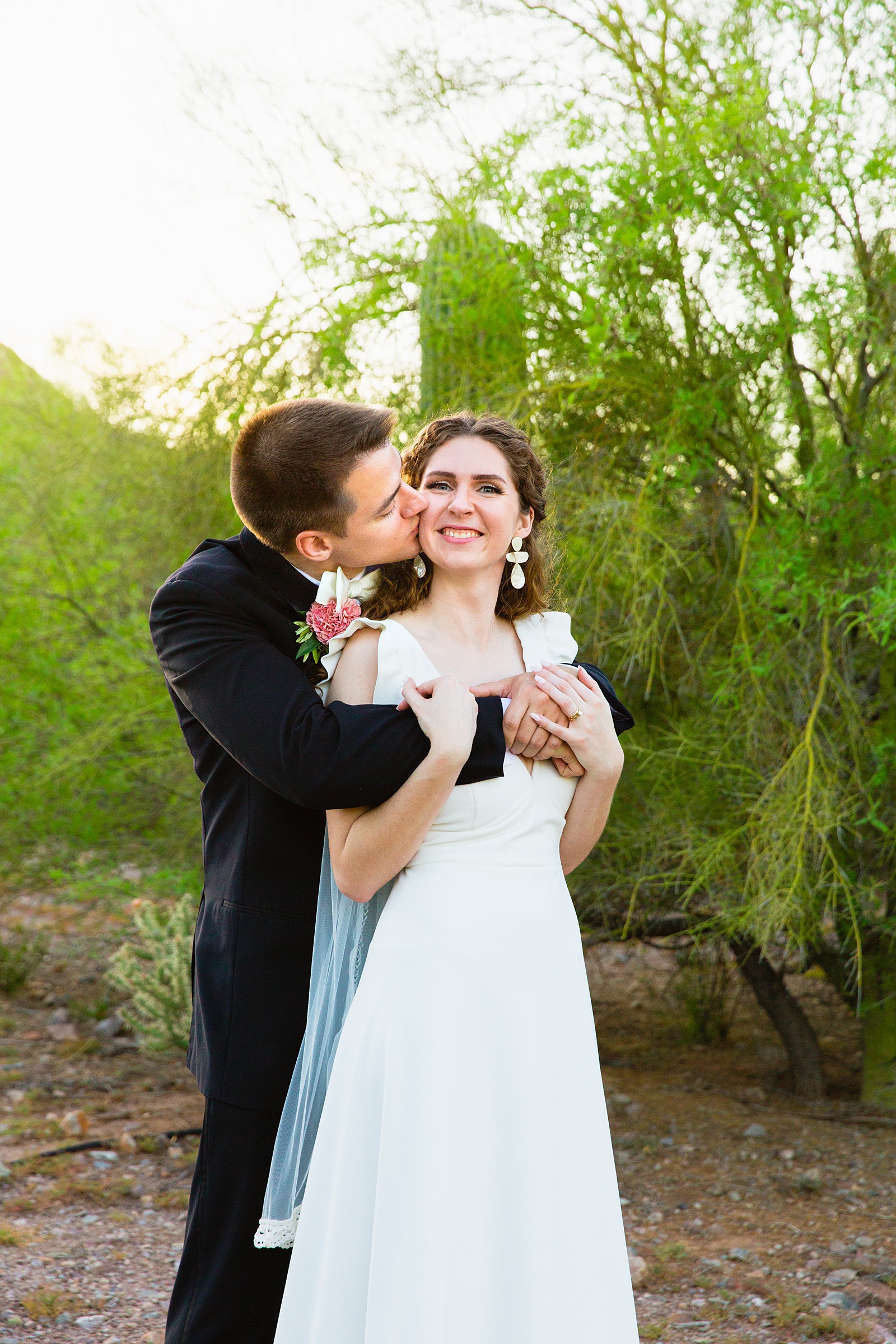 Bride and groom share a kiss during their Arizona Historical Society wedding by Tempe wedding photographer PMA Photography.
