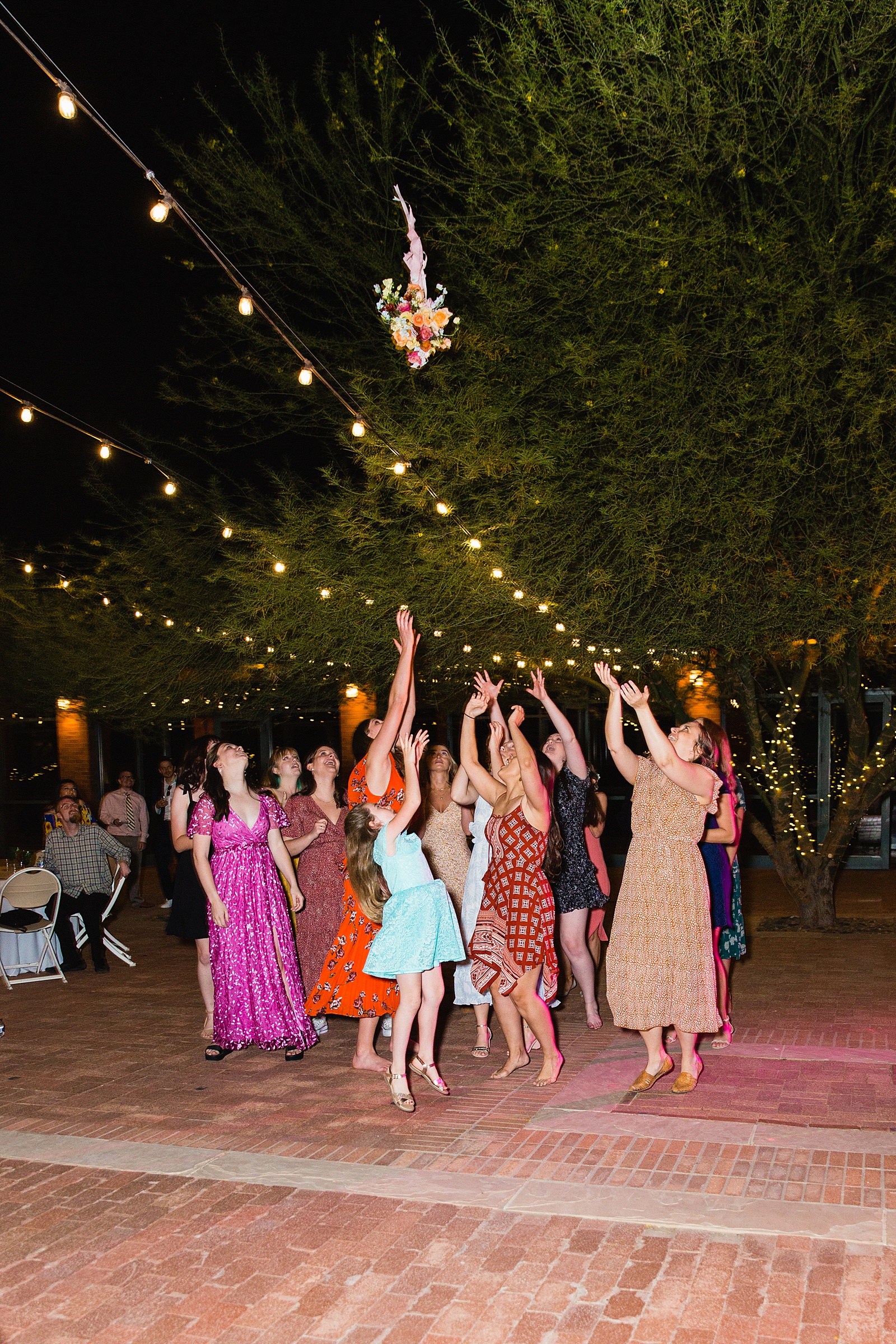 Bouquet toss at Arizona Historical Society wedding reception by Tempe wedding photographer PMA Photography.