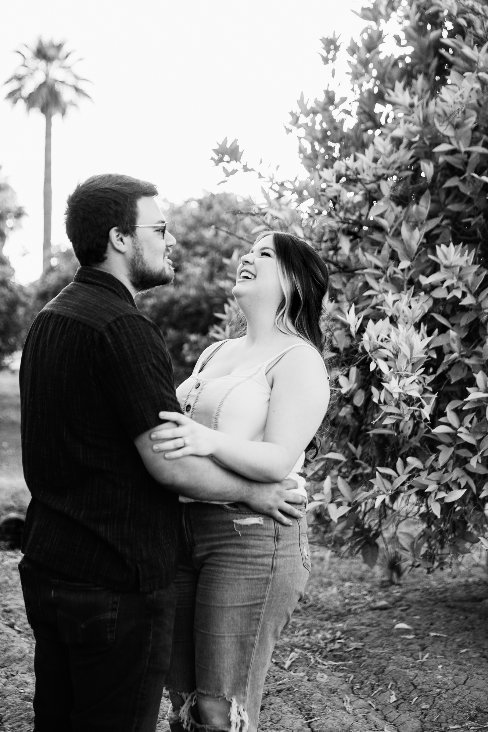 Couple laugh together during their Glendale engagement session by Arizona engagement photographer PMA Photography.