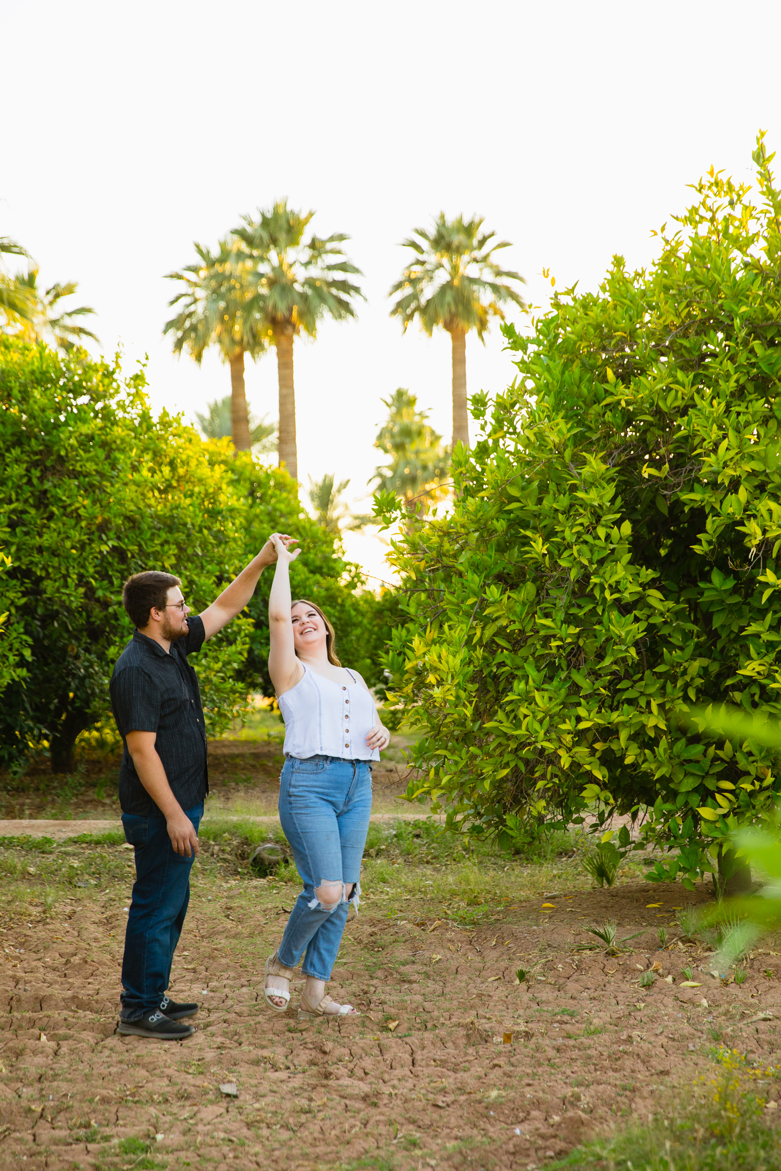 Couple having fun together during their Sahuaro Ranch engagement session by Glendale engagement photographer PMA Photography.
