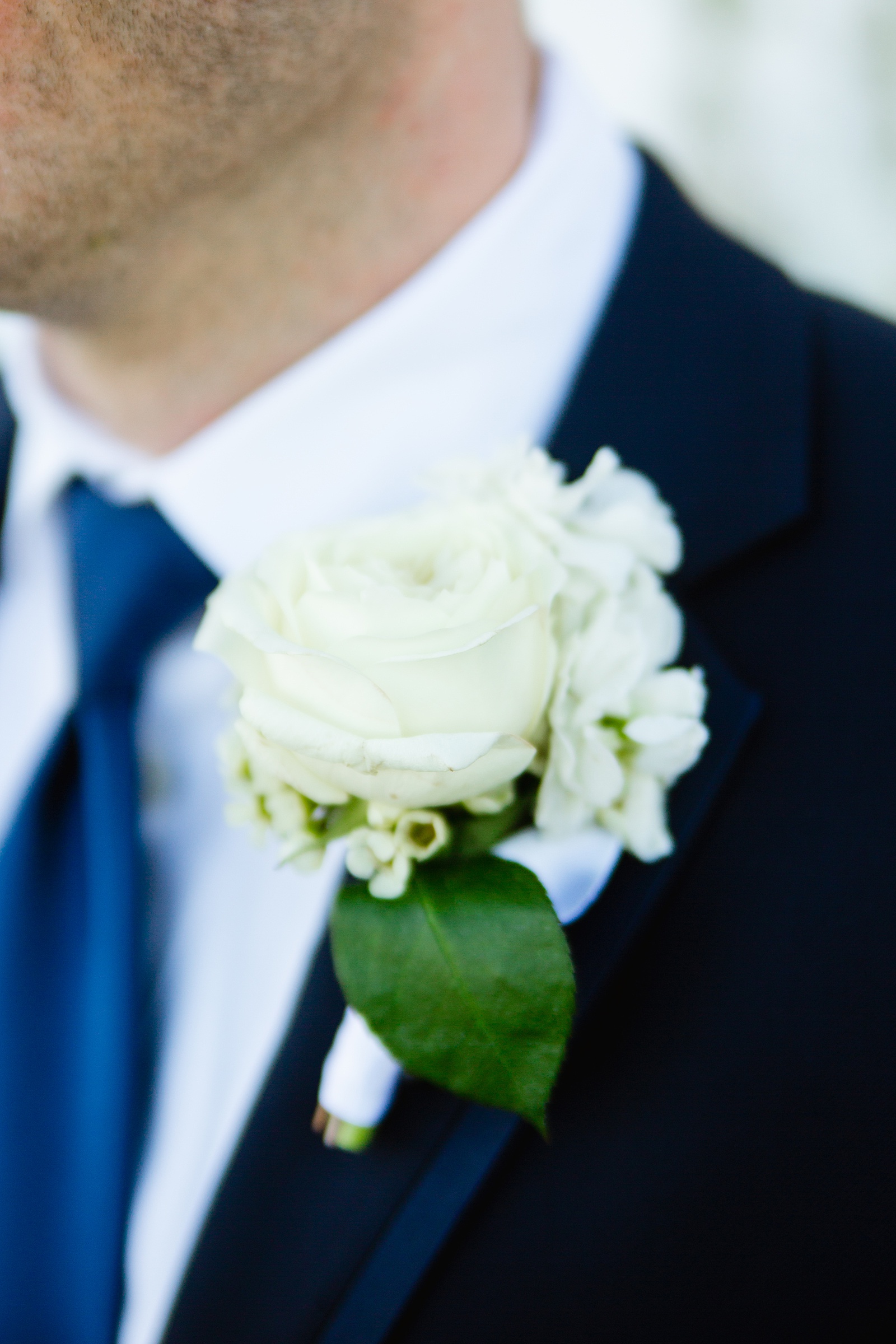 Groom's classic white rose boutonniere by PMA Photography.