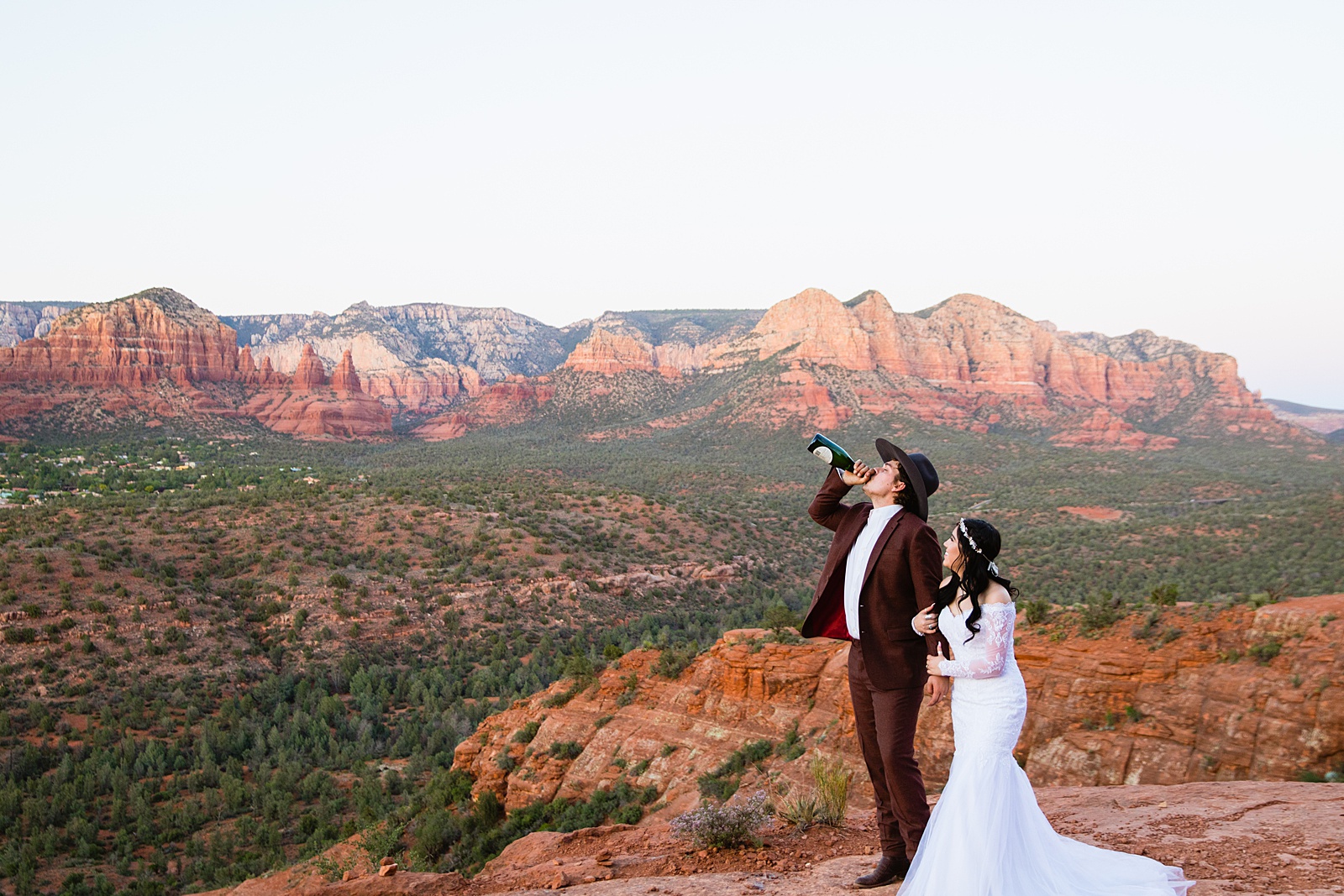 Bride and Groom celebrating with champagne for their Cathedral Rock elopement by Sedona elopement photographer PMA Photography.
